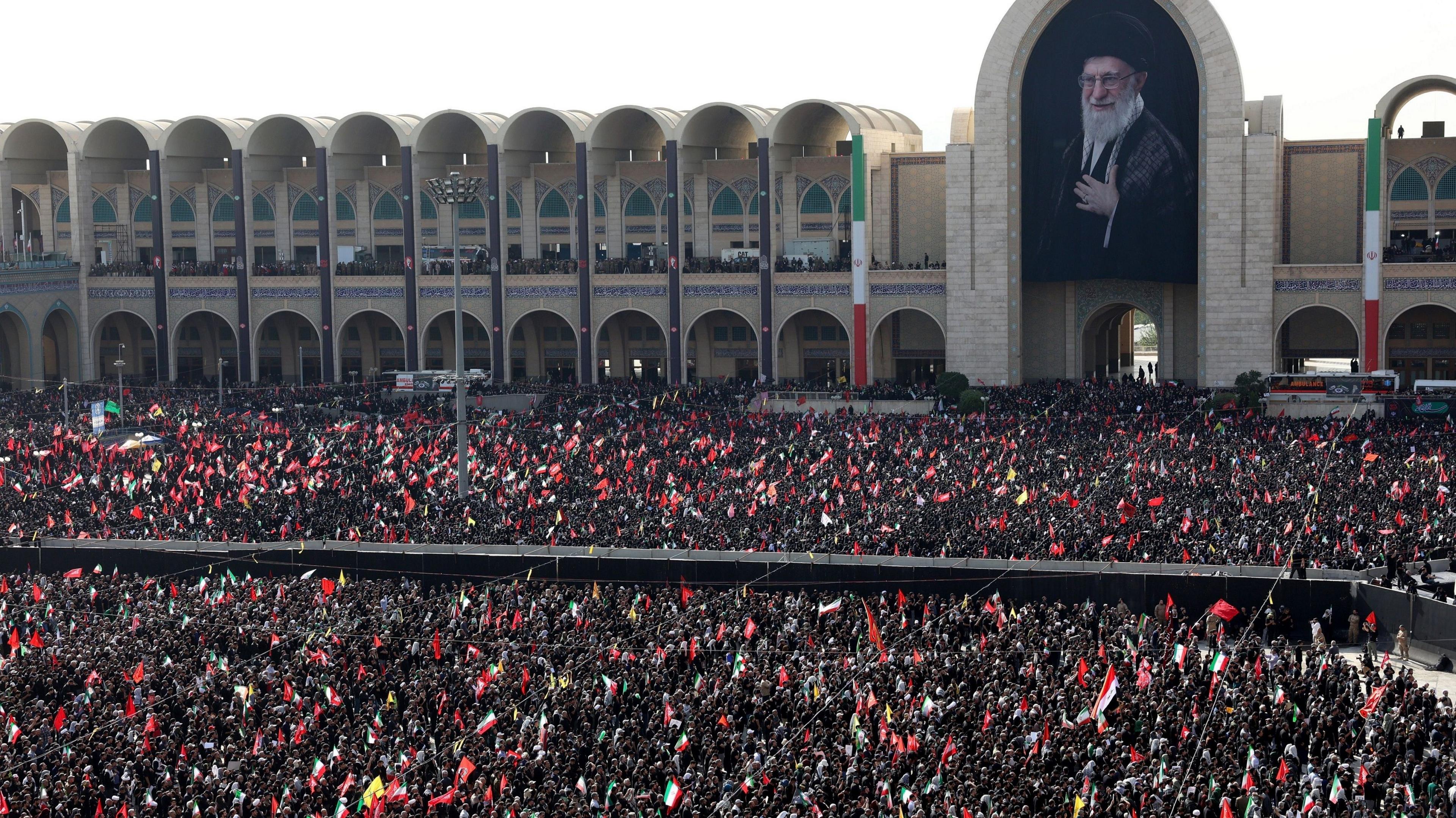 Thousands of Iranians gather in the courtyard of the Grand Mosalla below a large portrait of the late Ayatollah Khamenei
