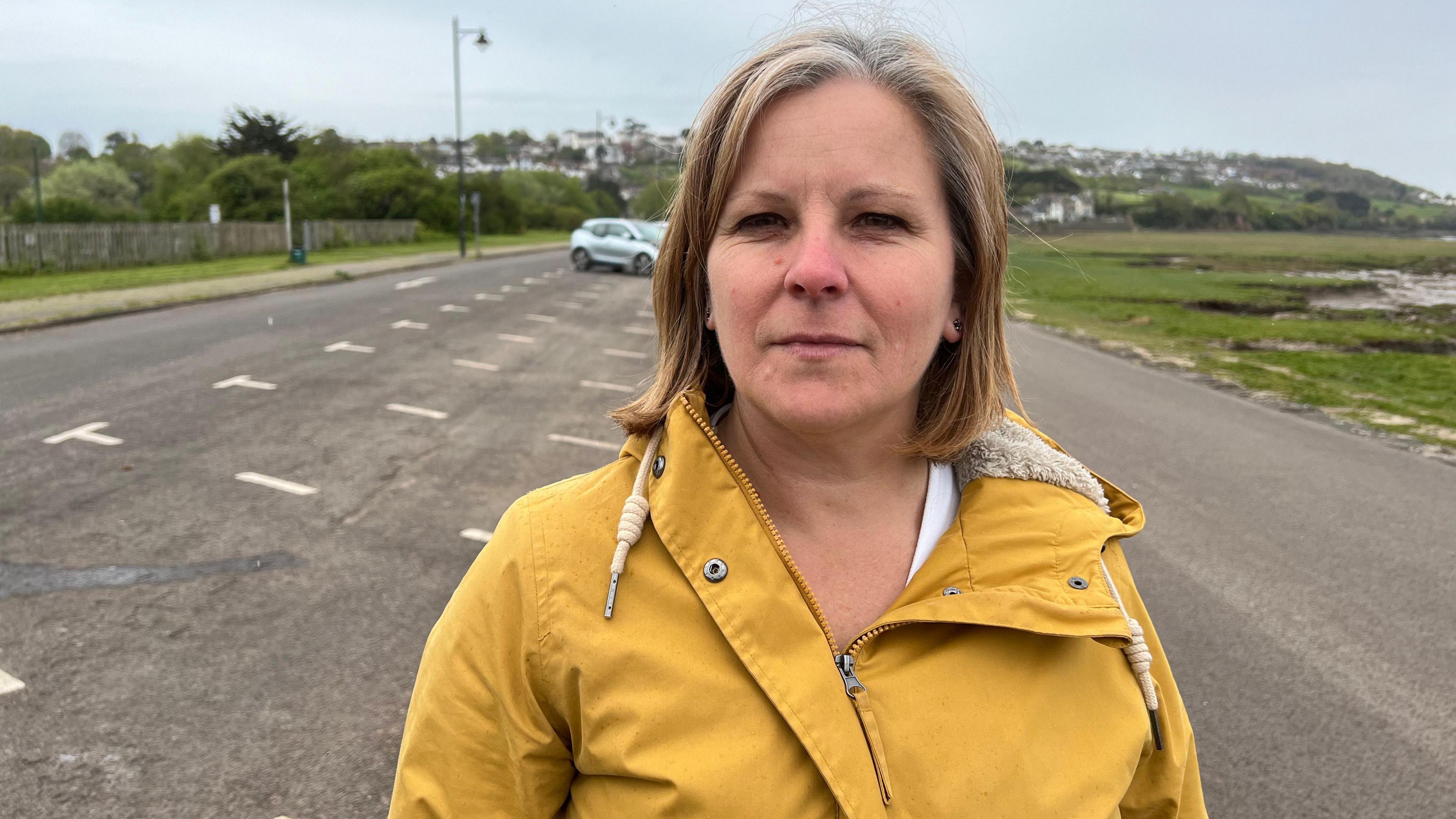 Hannah Young standing in front of empty car parking spaces behind her