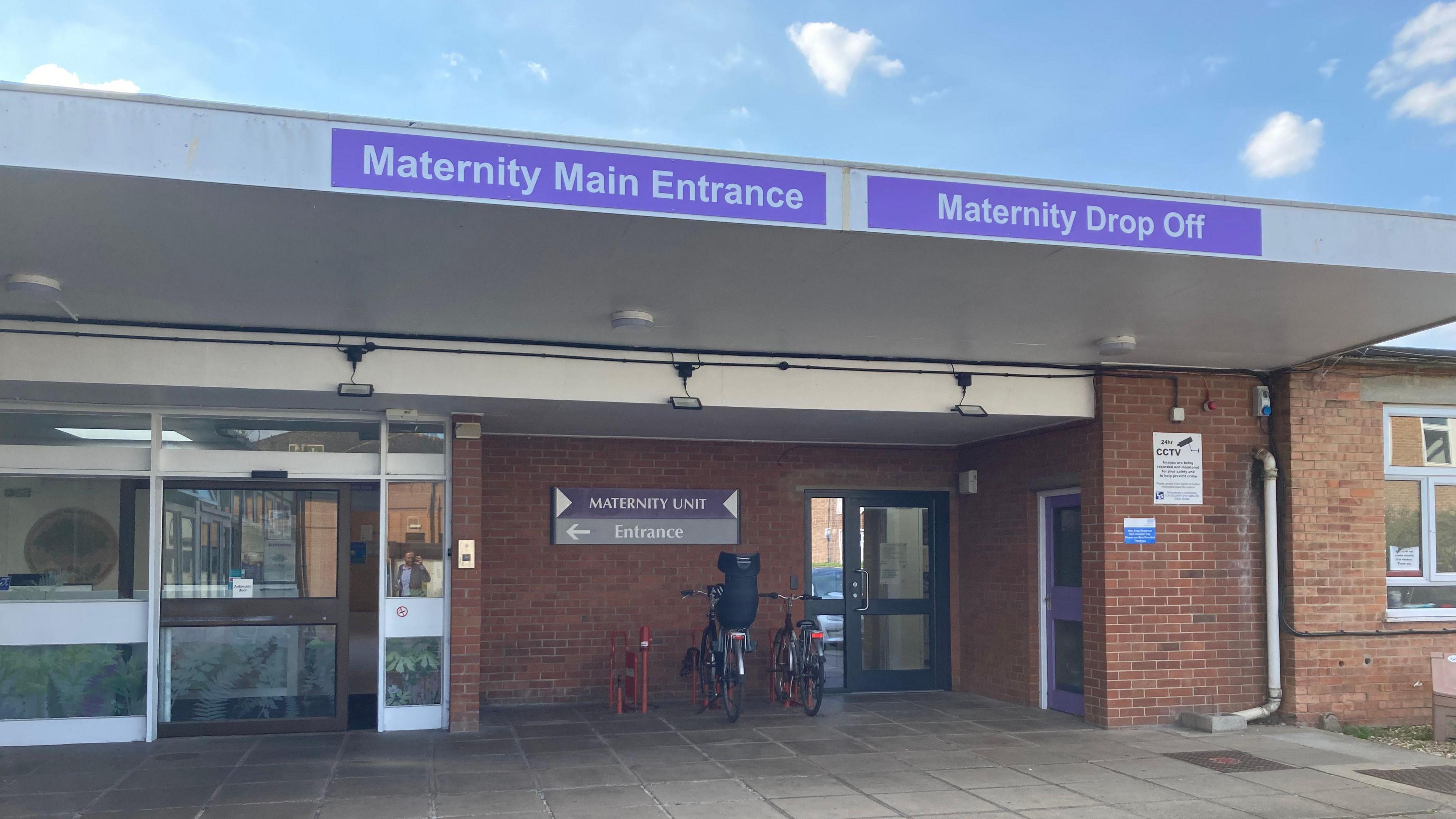 Old bricked building with big sign saying "Maternity Main Entrance" and "Maternity Unit Entrance"