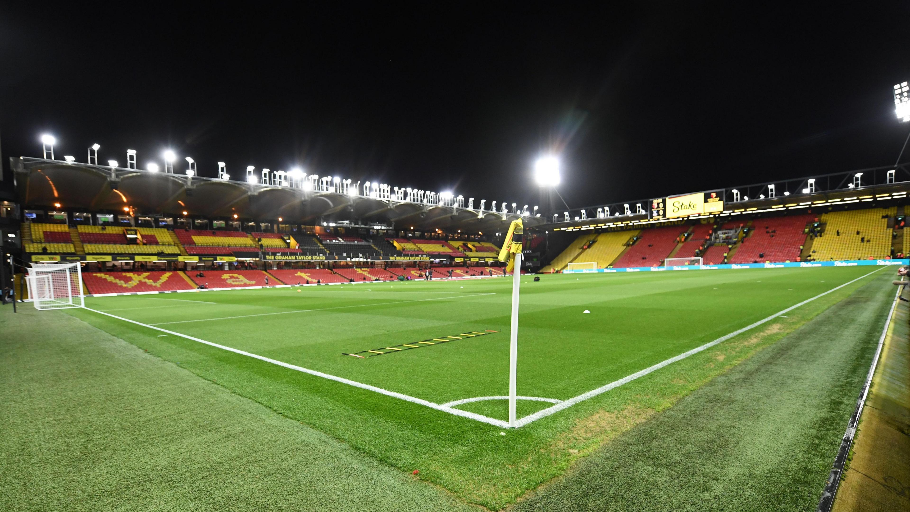 Watford's Vicarage Road stadium with the floodlights on 