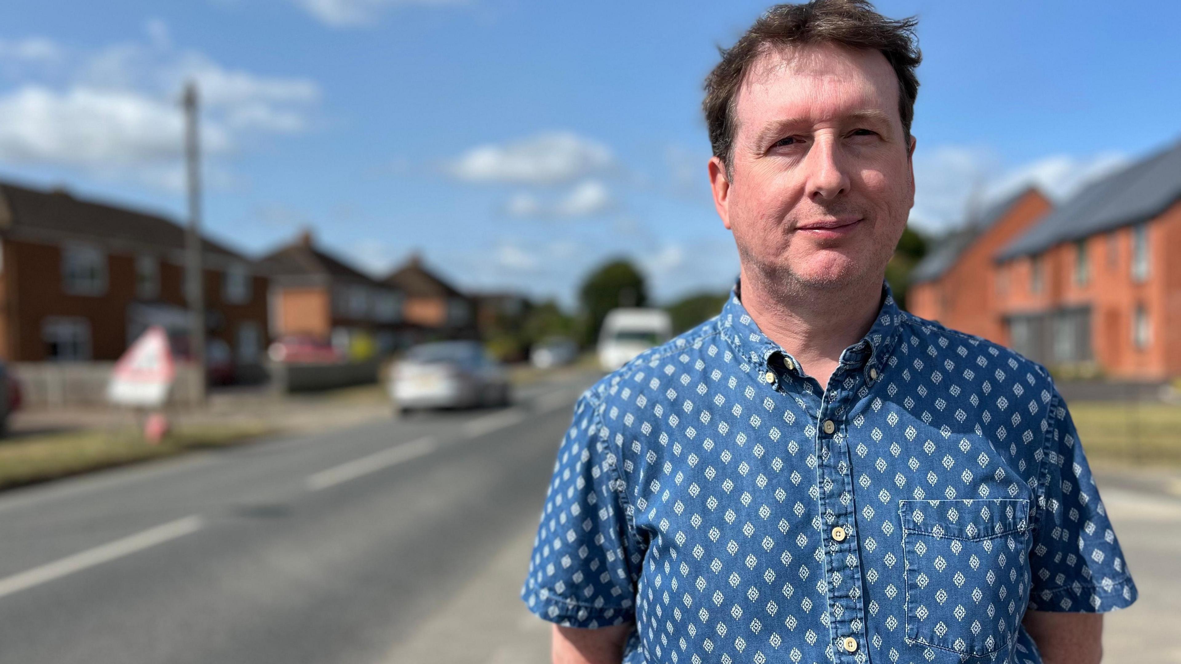 Image of Richard Hill who is a local resident standing on the side of Innsworth Lane. 