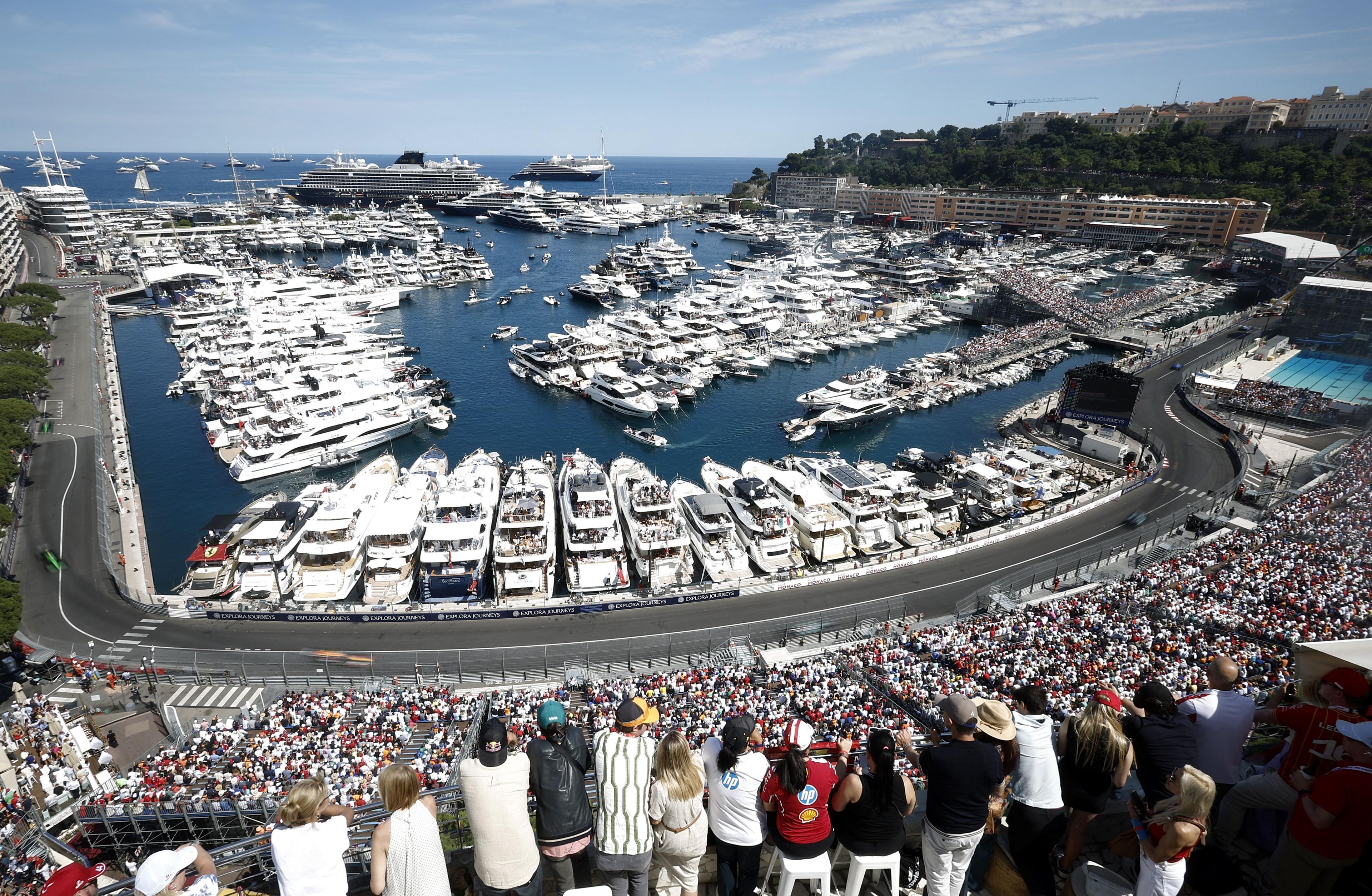 Yachts in the harbour in Monaco with spectators in the grandstand watching the grand prix below them
