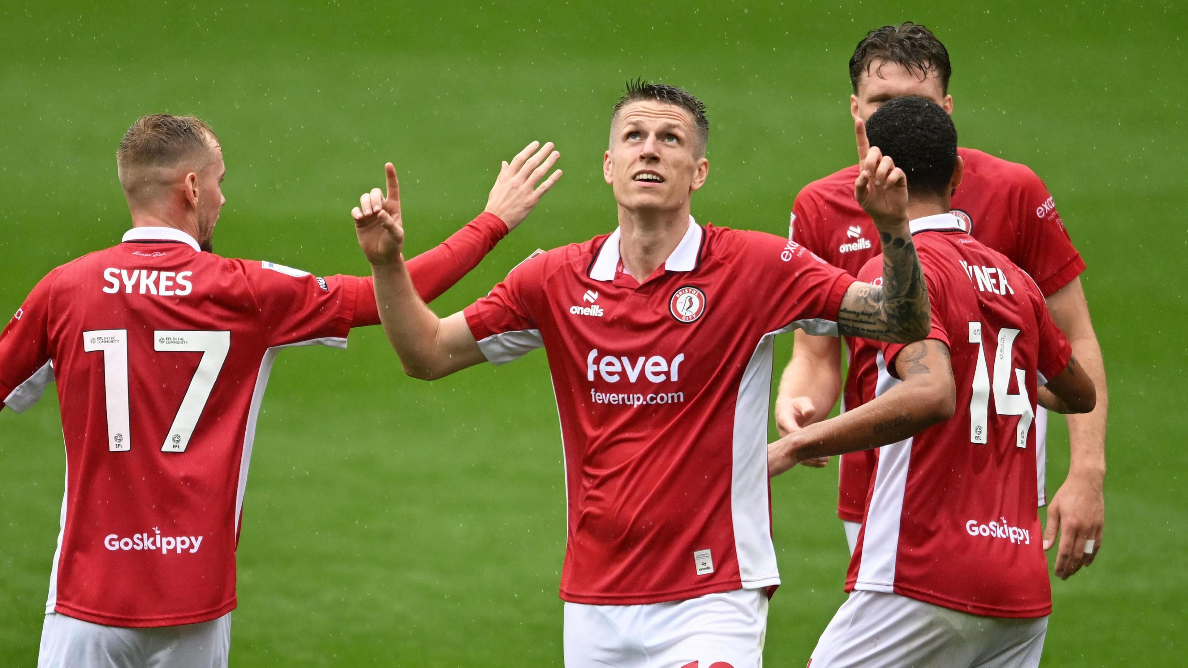 Bristol CIty players group together to celebrate a goal against Hull City at Ashton Gate. The scorer, Emil Riis Jakobsen, looks to the skies with his fingers pointing upwards