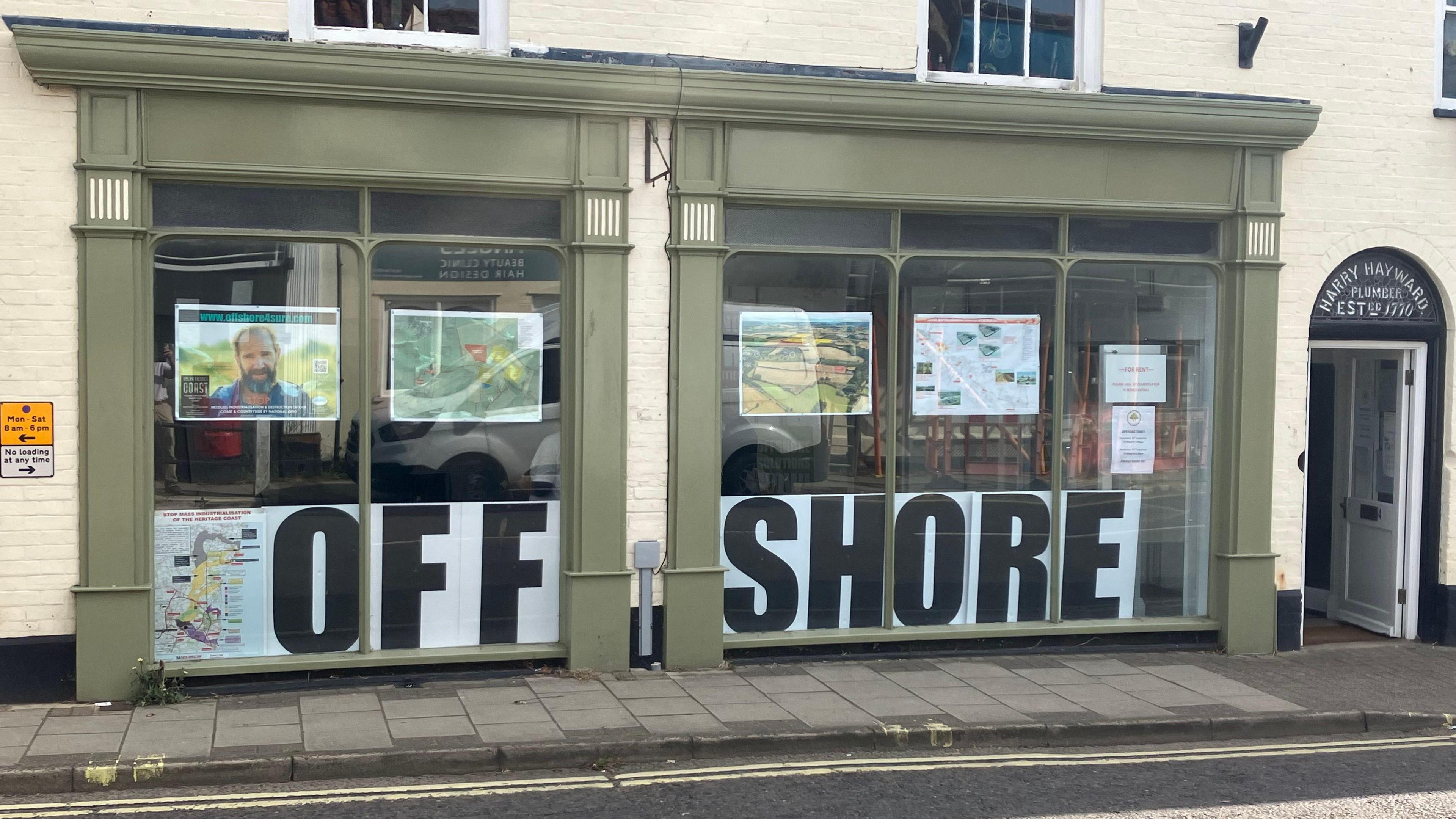 A green shop facade with the slogan "Offshore" written in large capital letters in the front window.