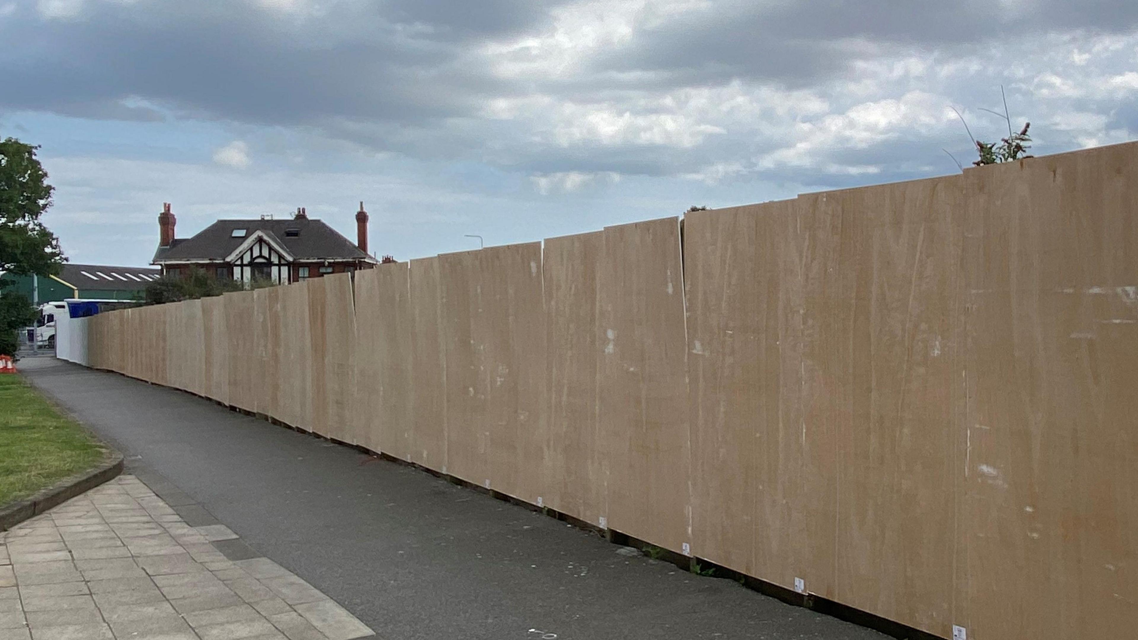 Blank, brown wooden boards lined up on a pathway, ready for street art to be painted on them