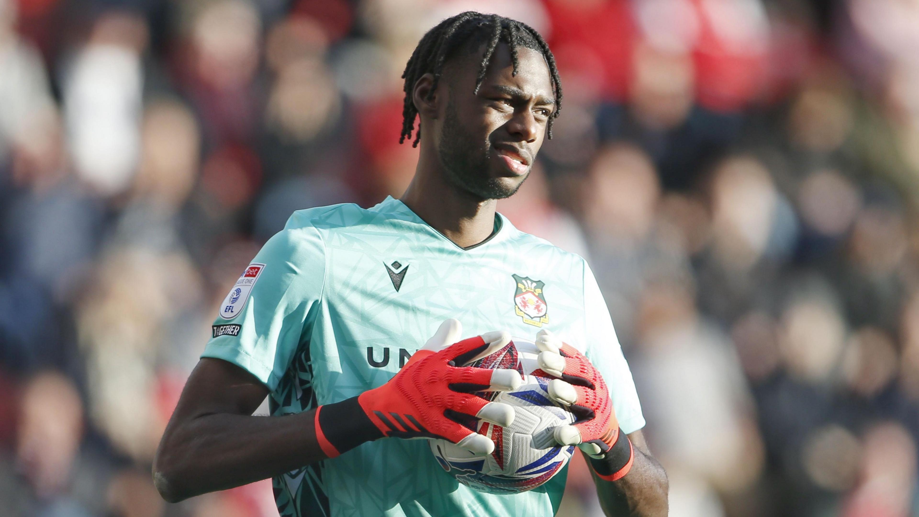 Wrexham goalkeeper Arthur Okonkwo clutches the ball