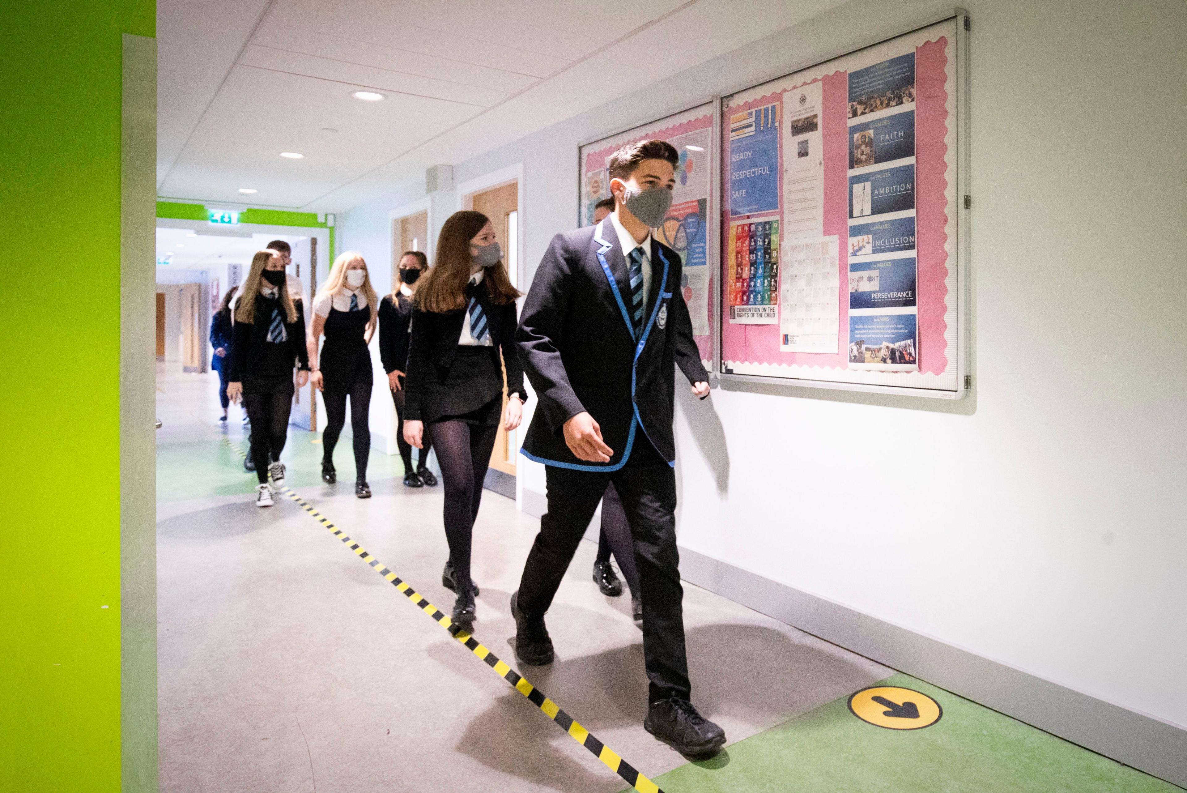 Pupils walking through a school observing social distancing measures 