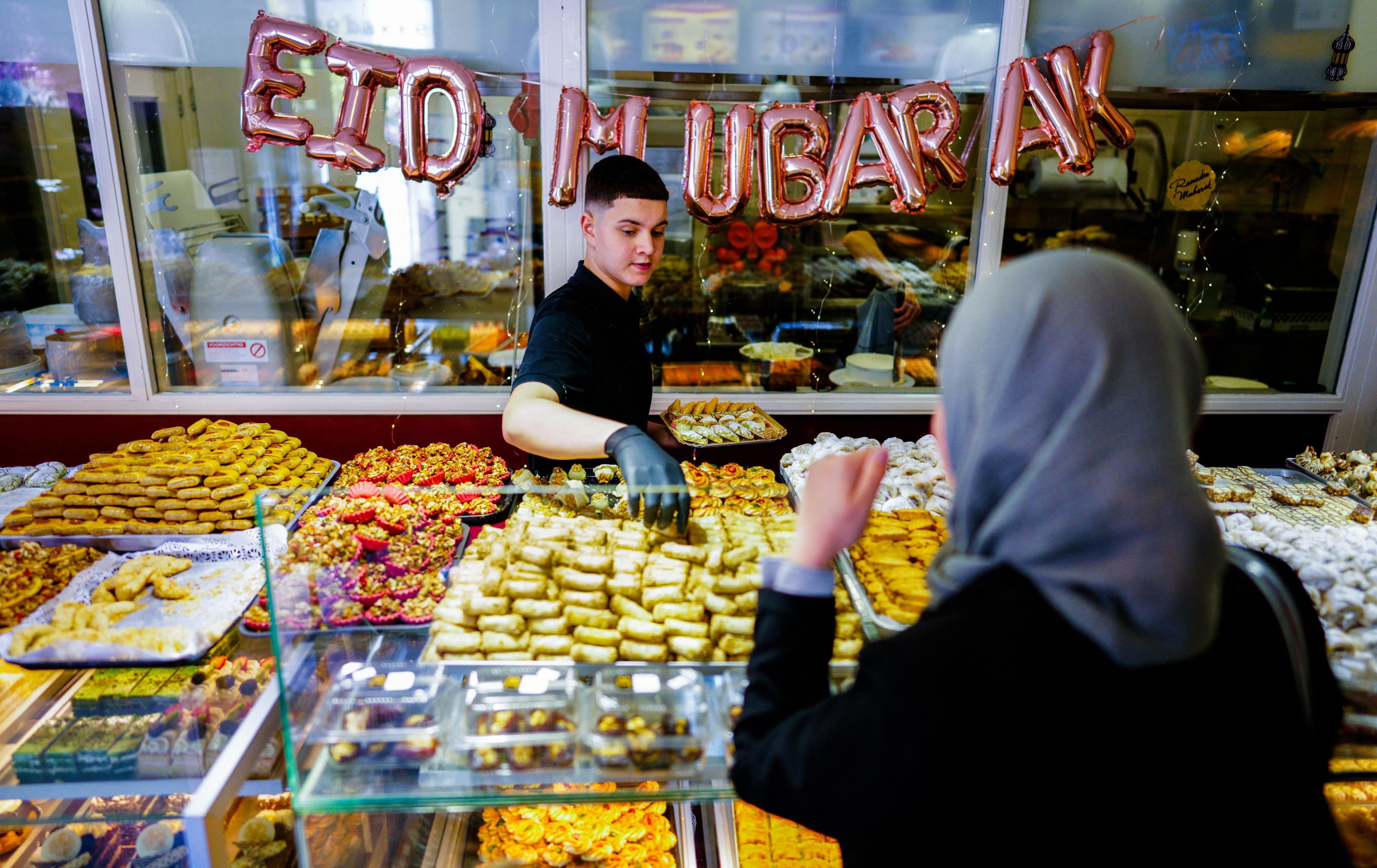 A woman buys pastries in Marrakesh, Morocco, for Eid al-Fitr