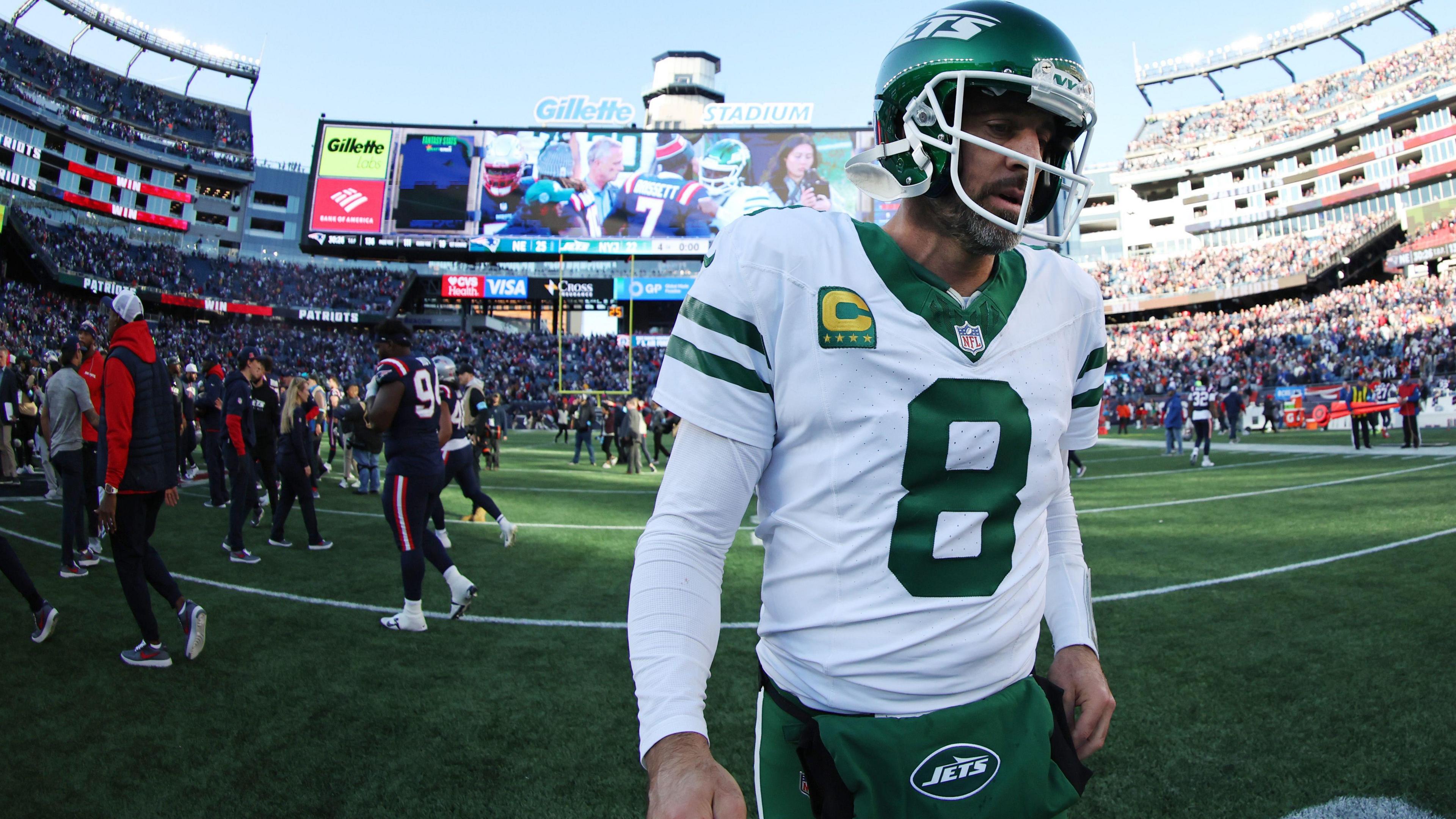 Aaron Rodgers of the New York Jets trudges off the field after losing to the New England Patriots