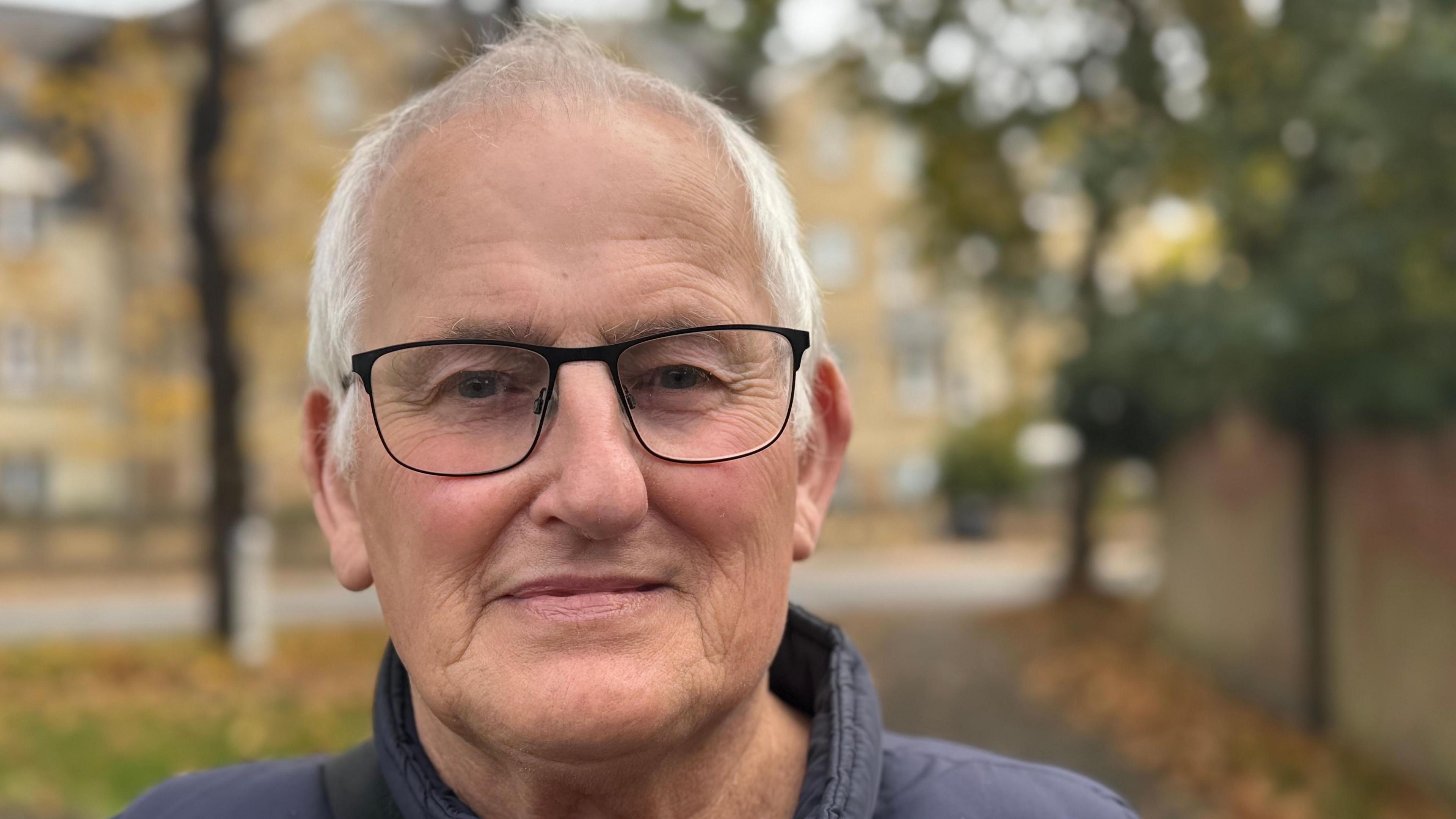 A close-up head and shoulders image of Andrew Haffer. He is wearing glasses, has grey hair, and is looking into the camera.