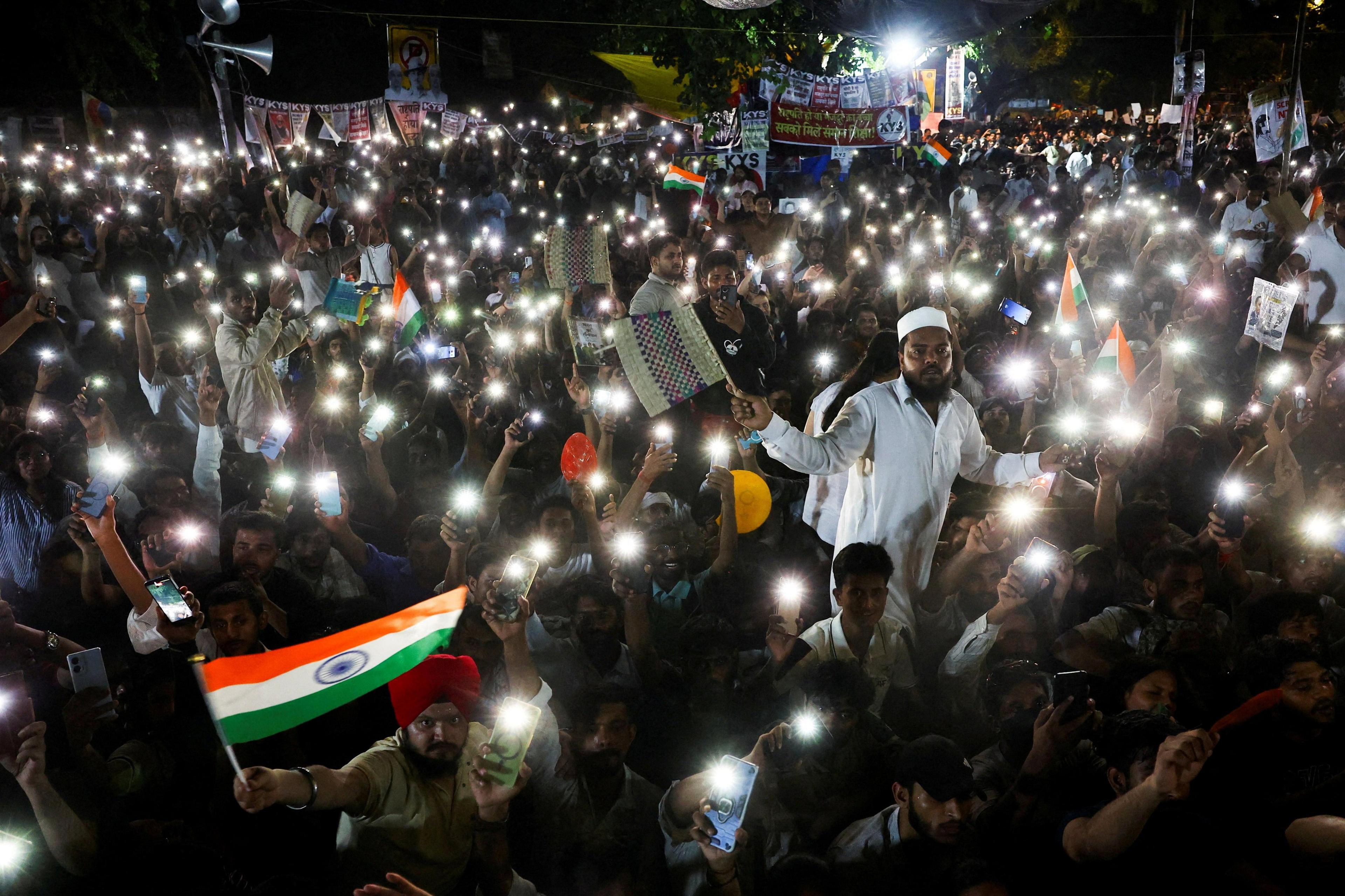 Supporters of the Cockroach Janta Party (CJP) chant slogans and wave their mobile phones with torches on as they gather after Indian education activist Sonam Wangchuk, who had been on a hunger strike, was taken to a hospital by authorities on Saturday during a sit-in protest demanding the resignation of Indian Education Minister Dharmendra Pradhan