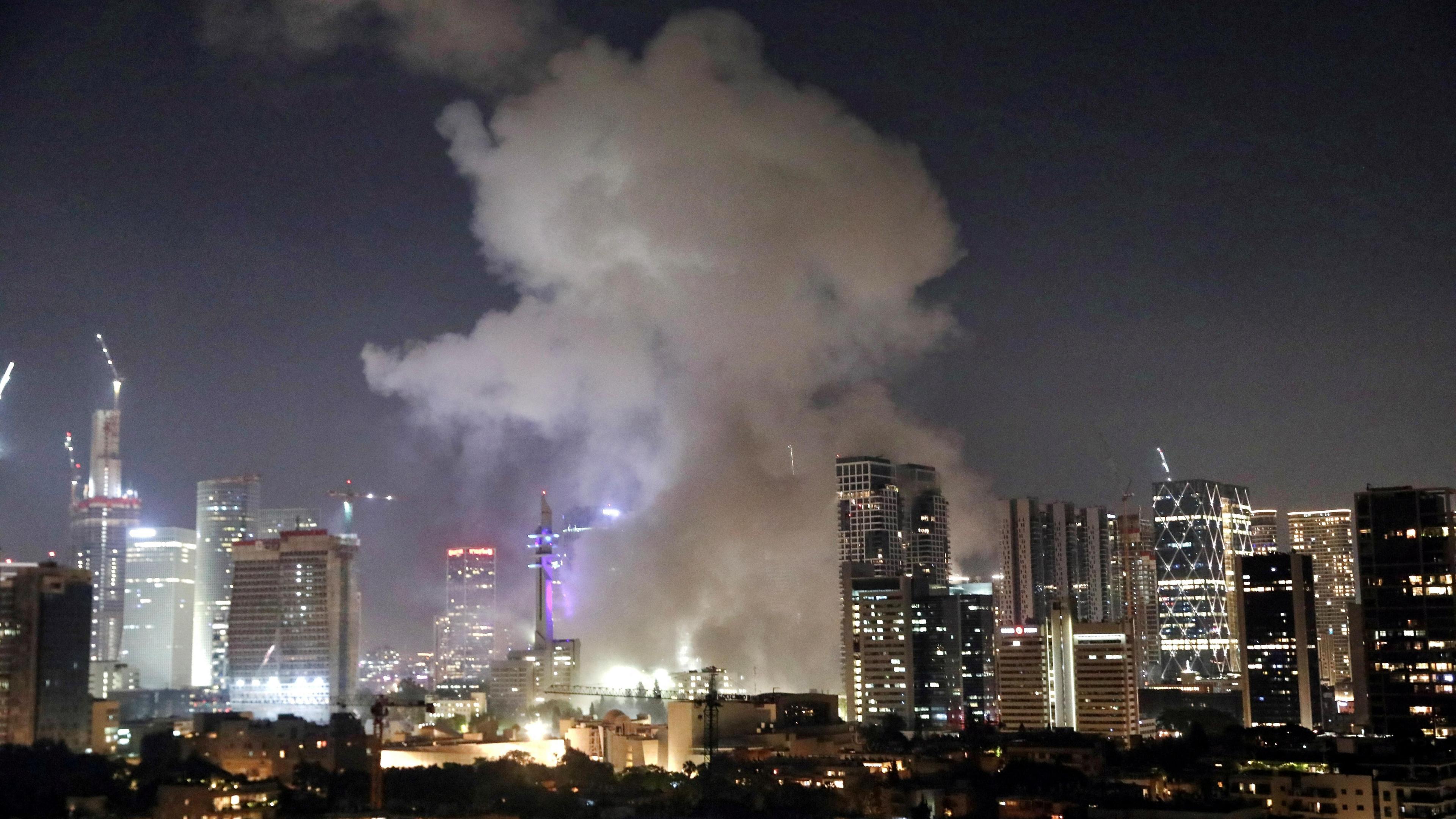 Smoke rising over a night time skyline in Tel Aviv, Israel.