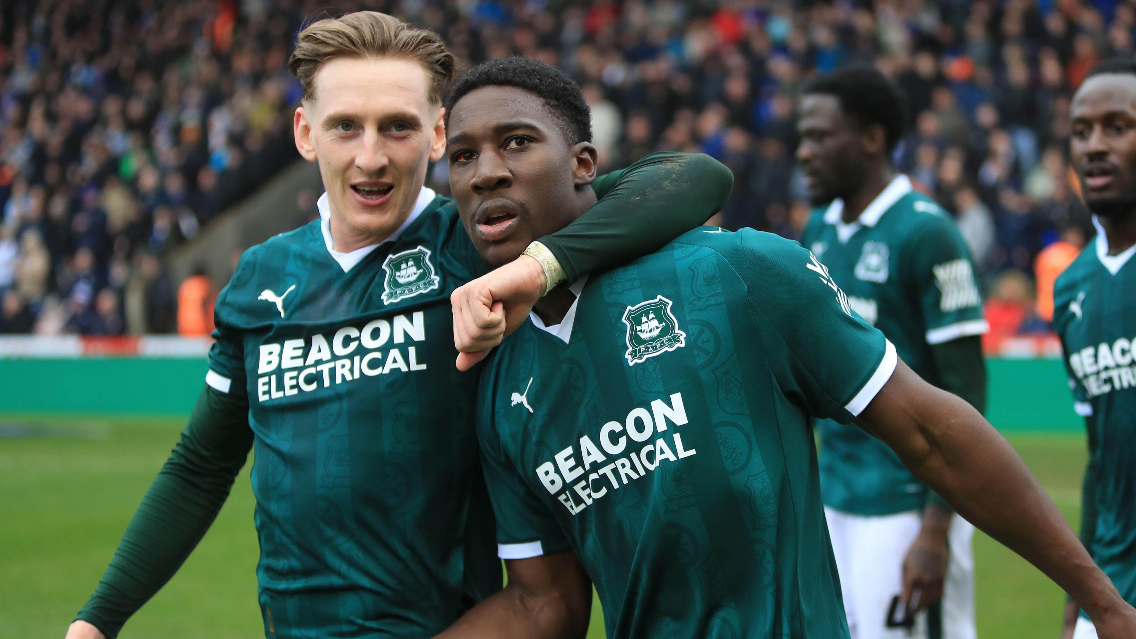 Plymouth players celebrate after scoring in their green tops
