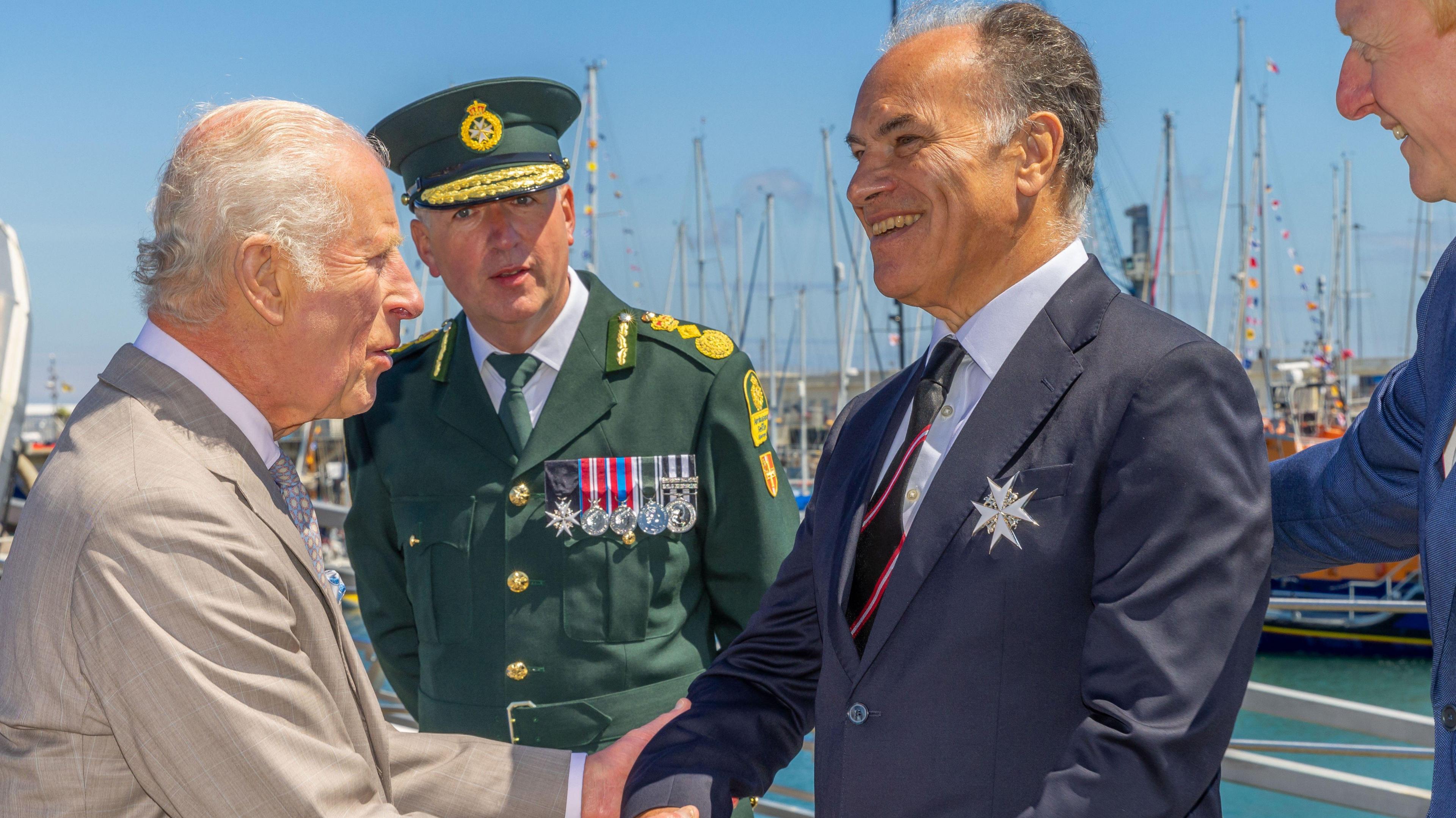 John Hollis shaking hands with King Charles III