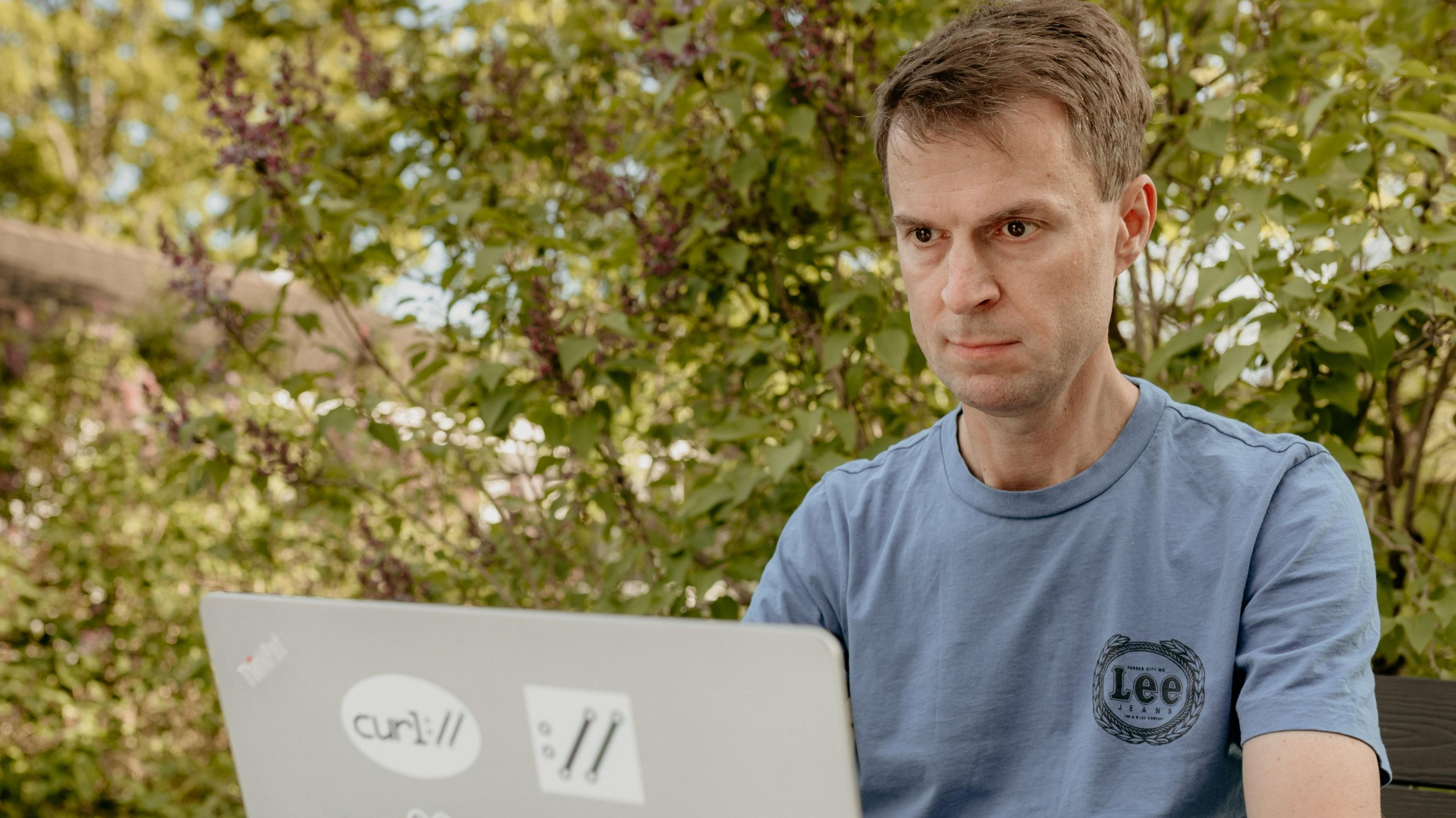 Daniel Stenberg works at his laptop which has stickers on the back