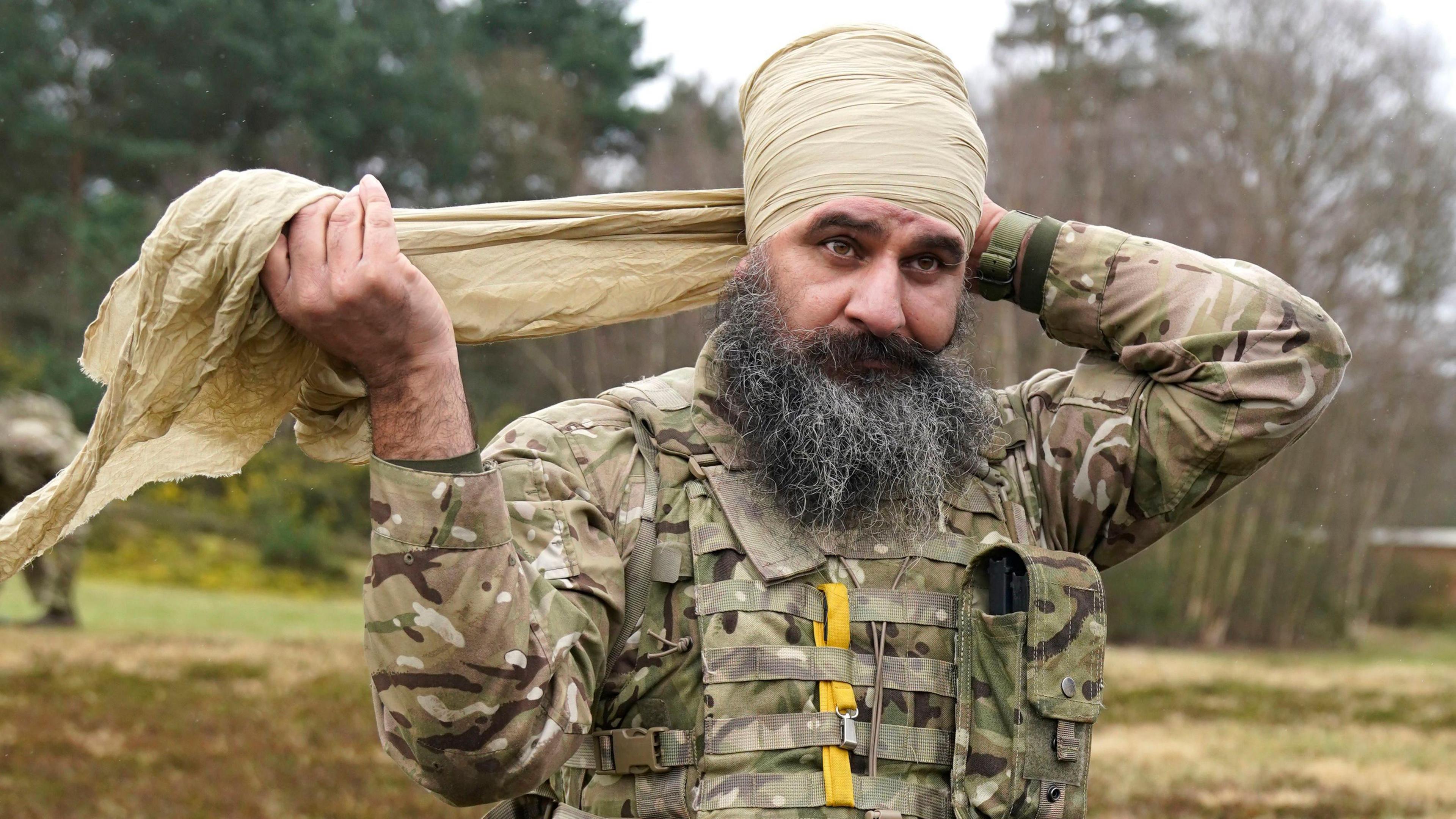 Major Harj Singh Shergill ties a Dumalla after taking part in a shooting competition during the Holla Mahalla Sikh military festival, at the Aldershot Garrison, Hampshire