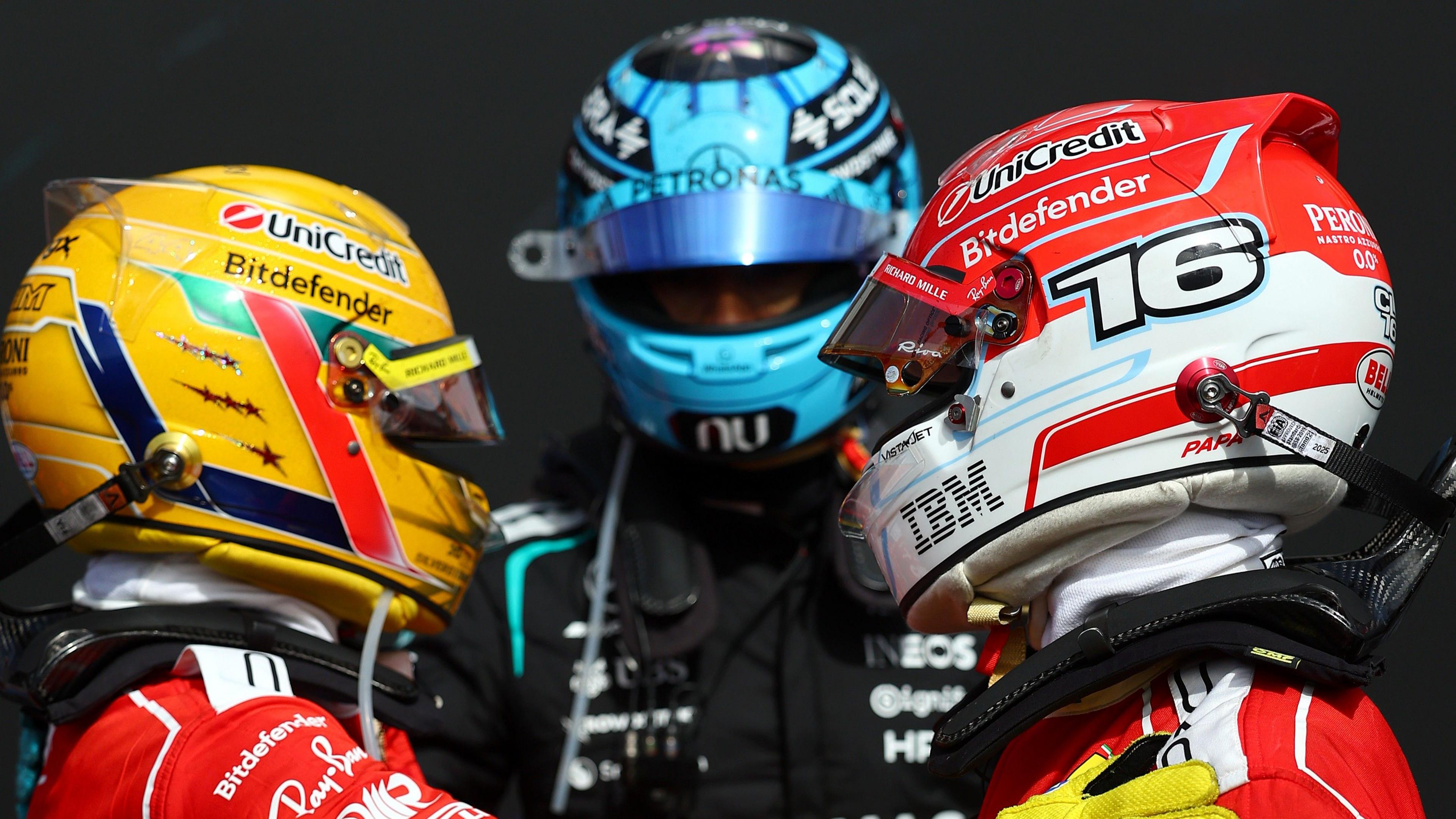 Race winner Ferrari's Charles Leclerc hugging team-mate Lewis Hamilton and second place George Russell watches the pair behind them
