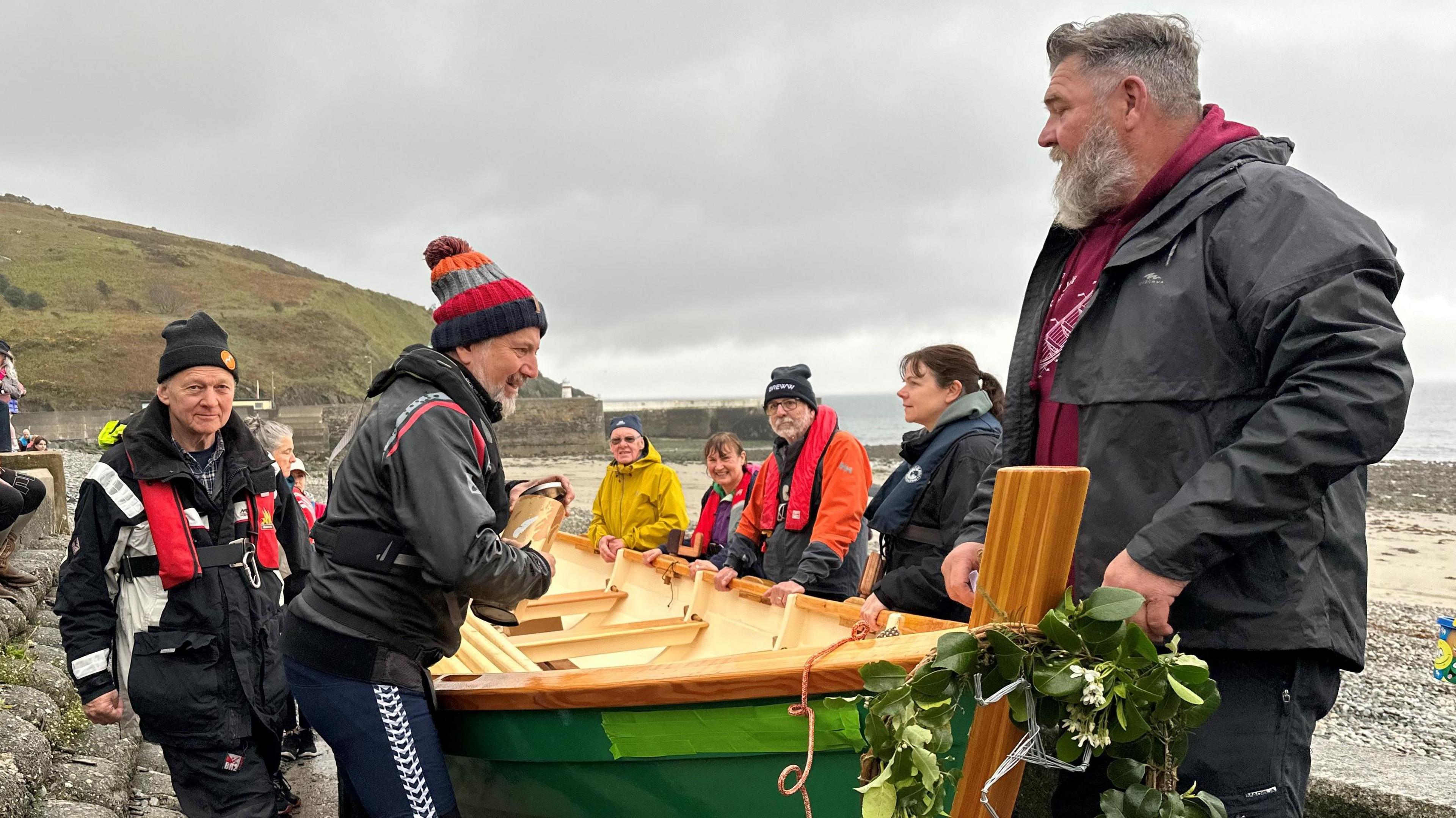 People standing next to the skiff