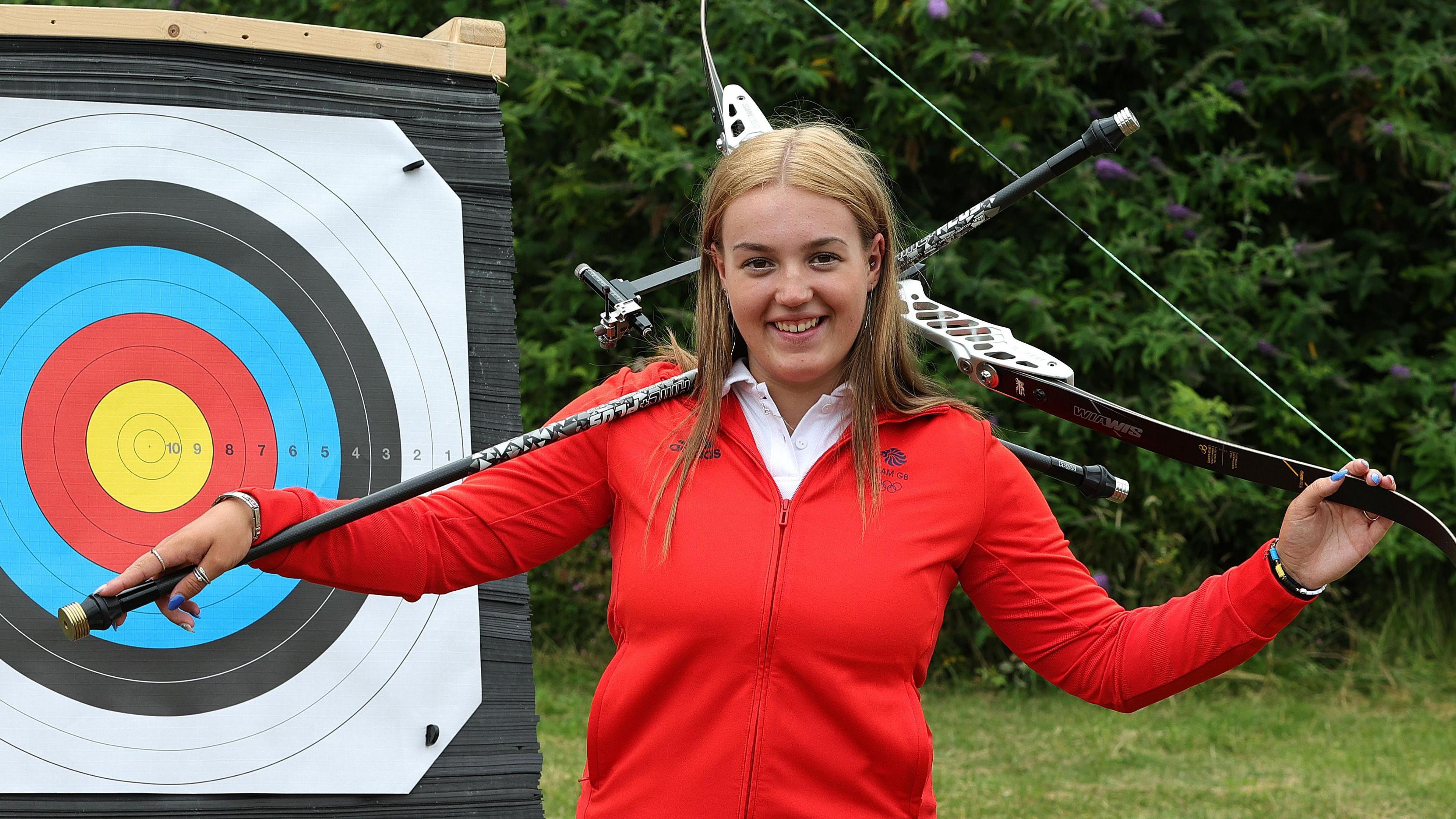 Megan Havers poses in front of a target with her archery equipment after being selected for Team GB