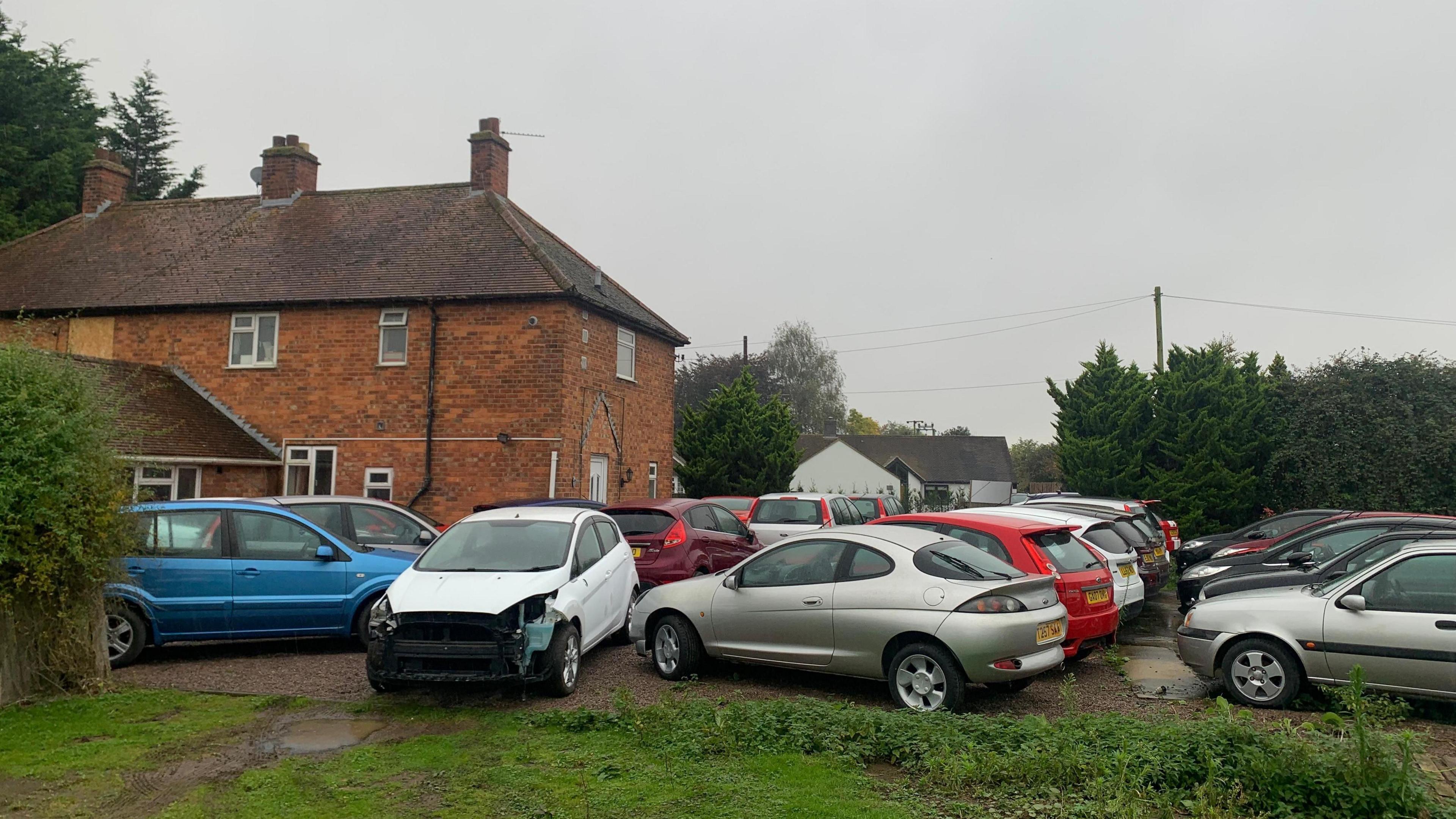 A car park of Ford Fiestas on Mr Smith's land, next to his house.