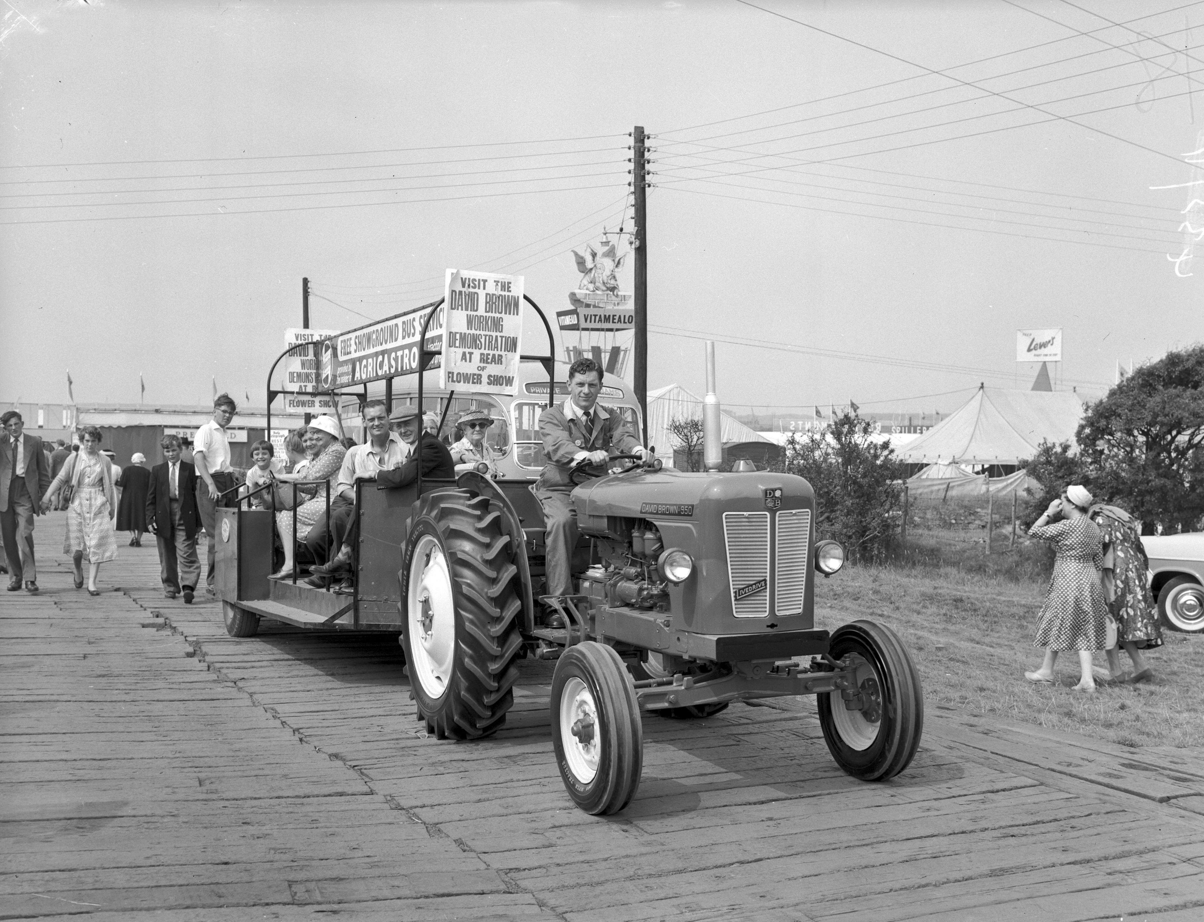 Tractor yn mynd a phobl o gwmpas