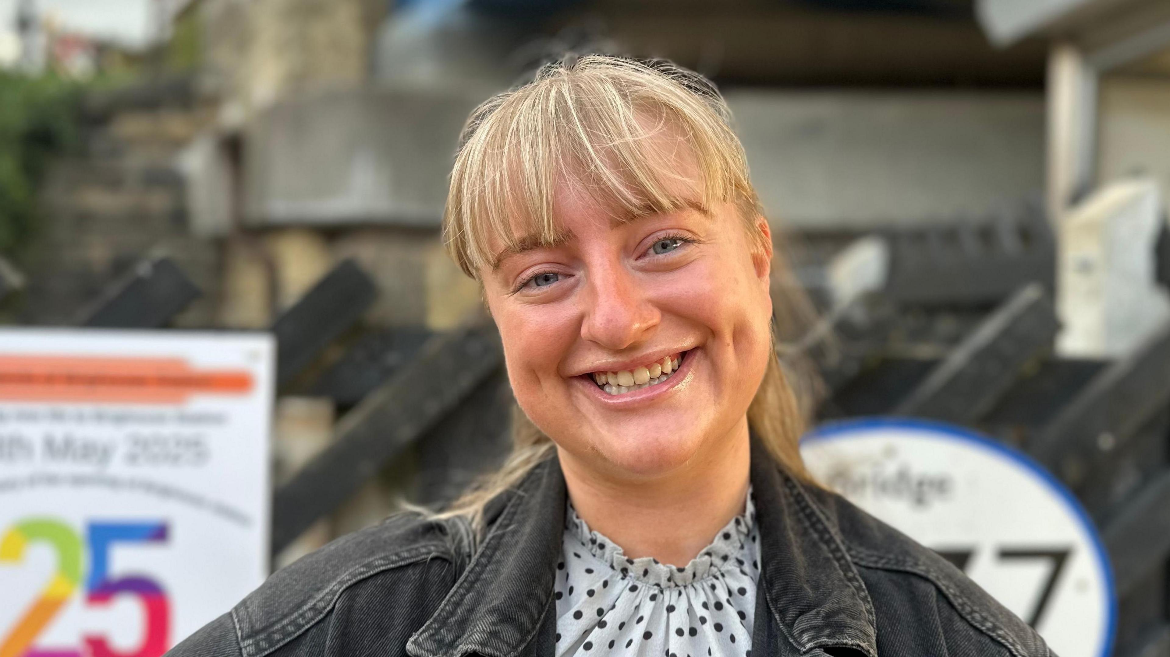 Emily Coull, who has blonde hair and blue eyes. She is smiling at the camera in the photo.
