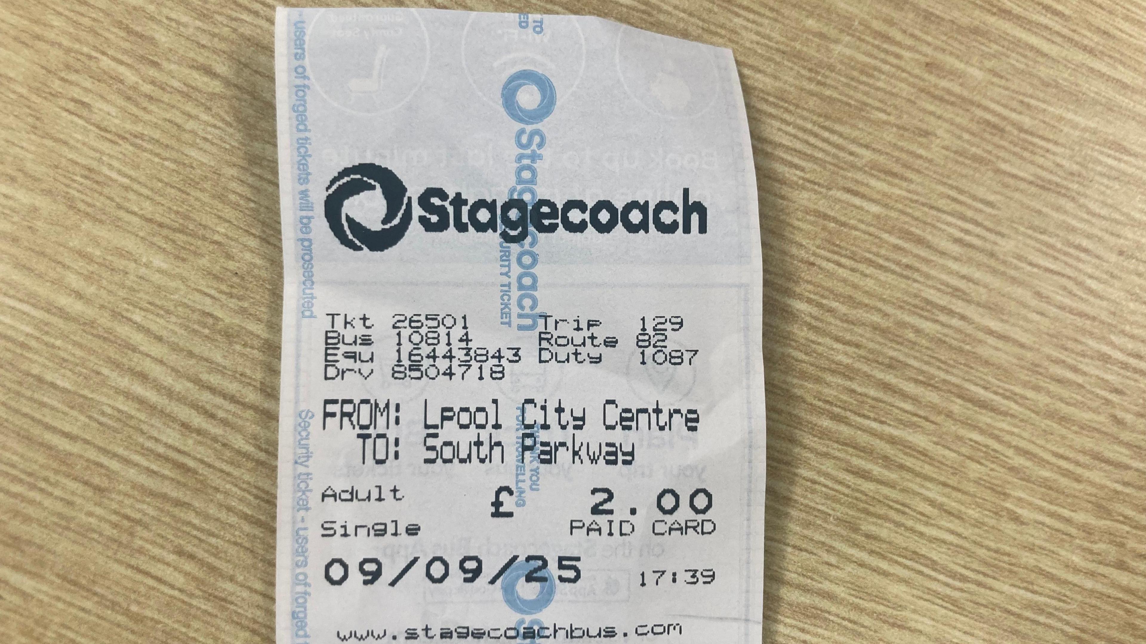 A receipt for a £2.00 Stagecoach bus fare lying on a wooden table.
