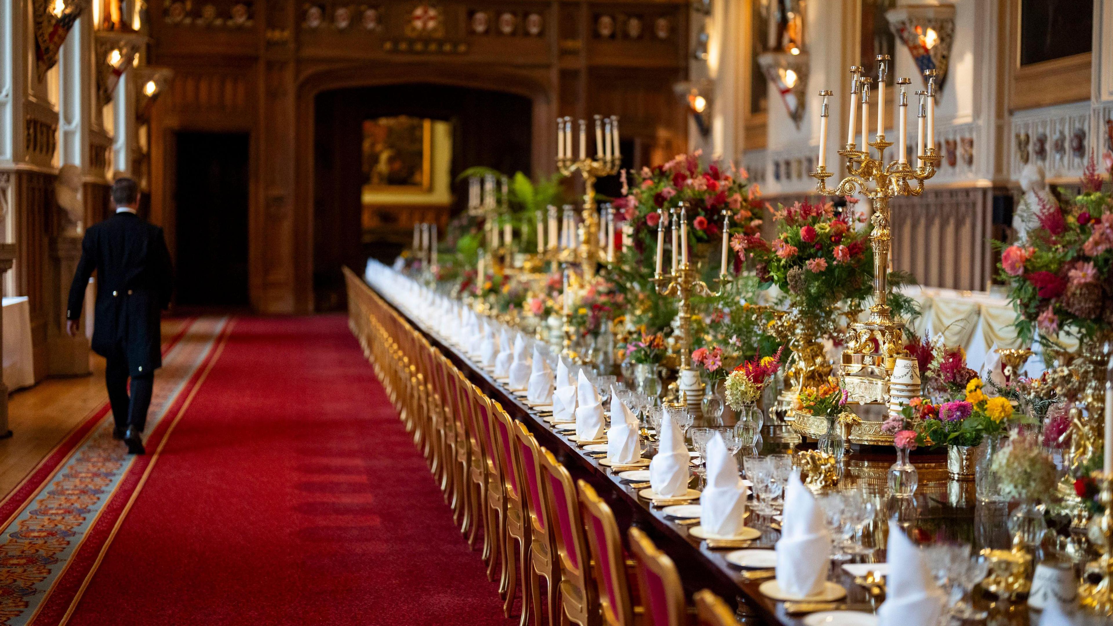 A view of the banquet table, with gold candlesticks and lots of pink and red flowers