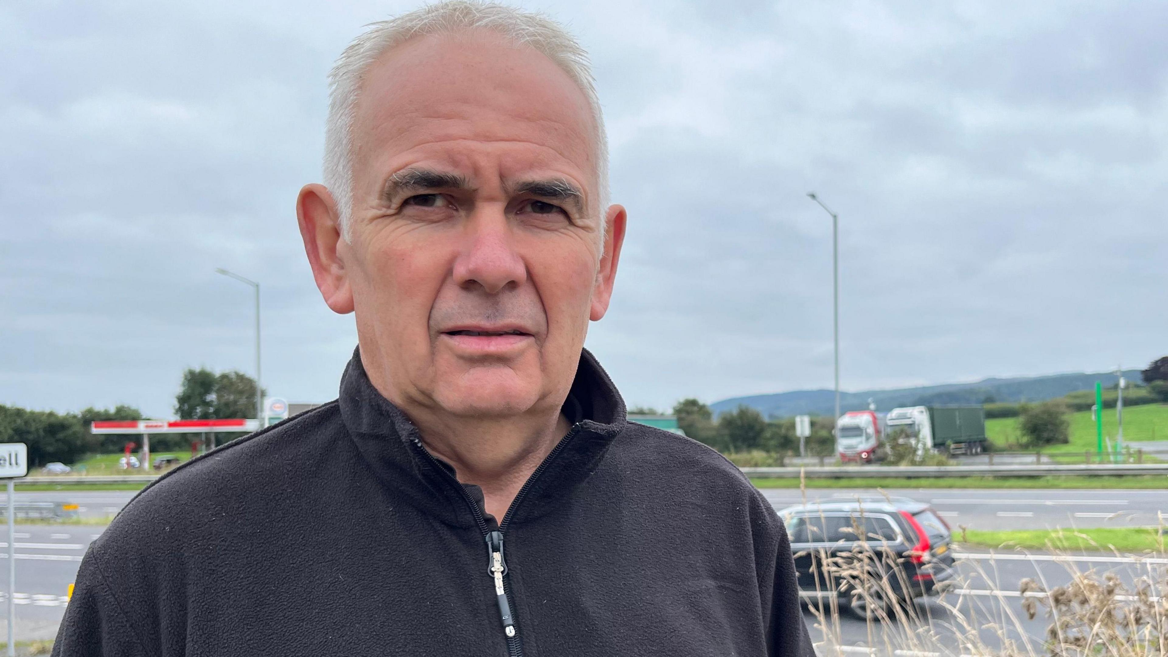 Local farmer Ian Scott standing beside the A30 at Plusha