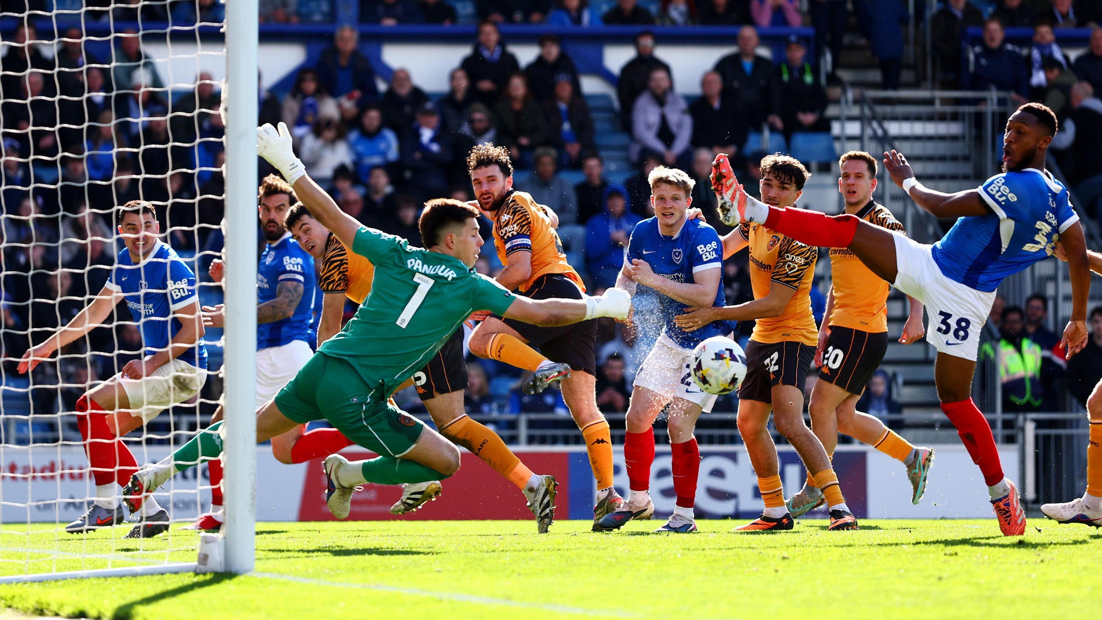 Ivor Pandur of Hull City makes a save in the game against Portsmouth at Fratton Park as various players from both teams watch on.
