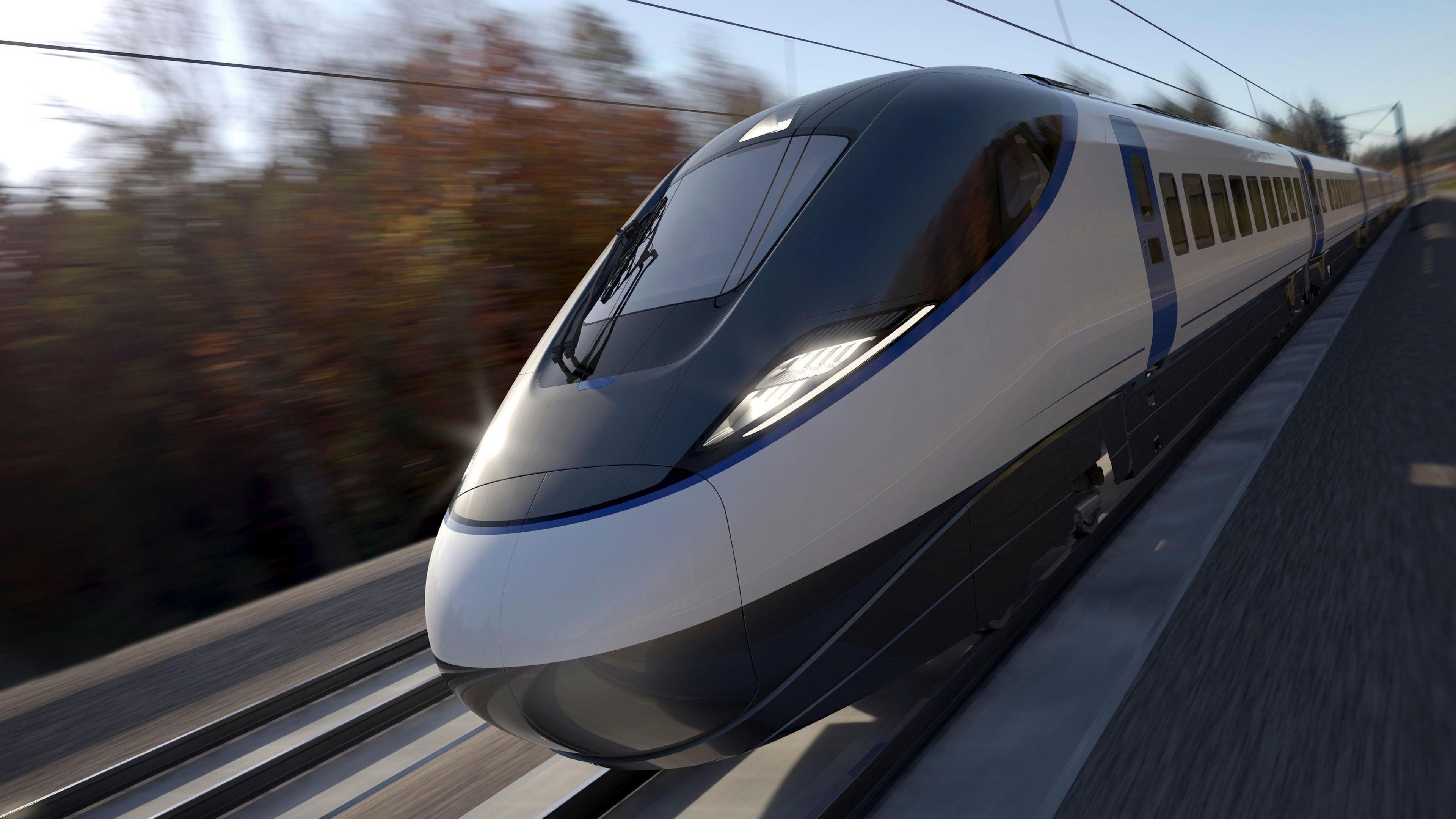 An artists' impression of an HS2 train. The train has a bullet shaped front with large glass windows and is running on rail lines through a background of trees which are blurred to imply the speed of the train.