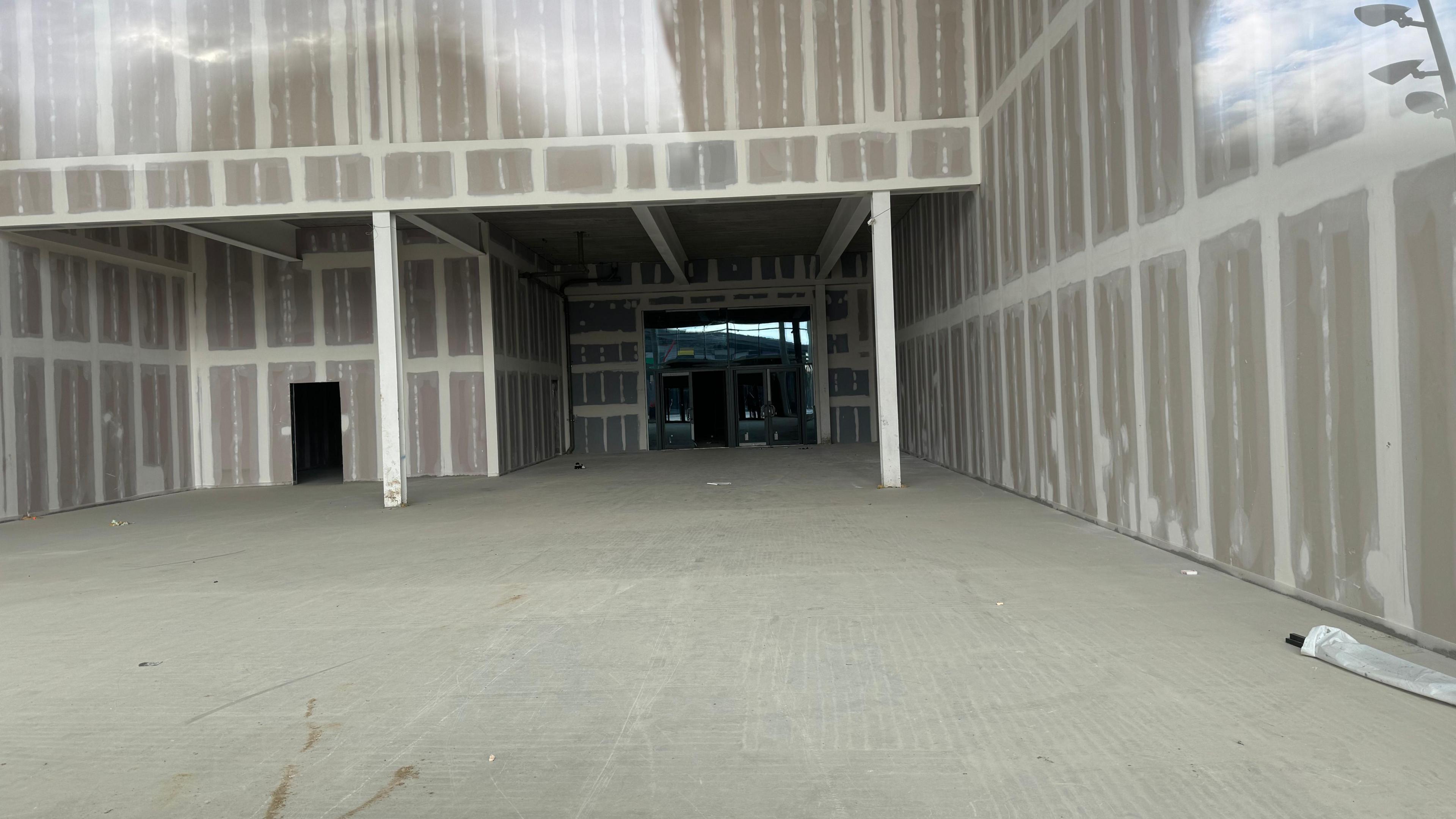 Inside a commercial unit. There is a concrete floor and walls.