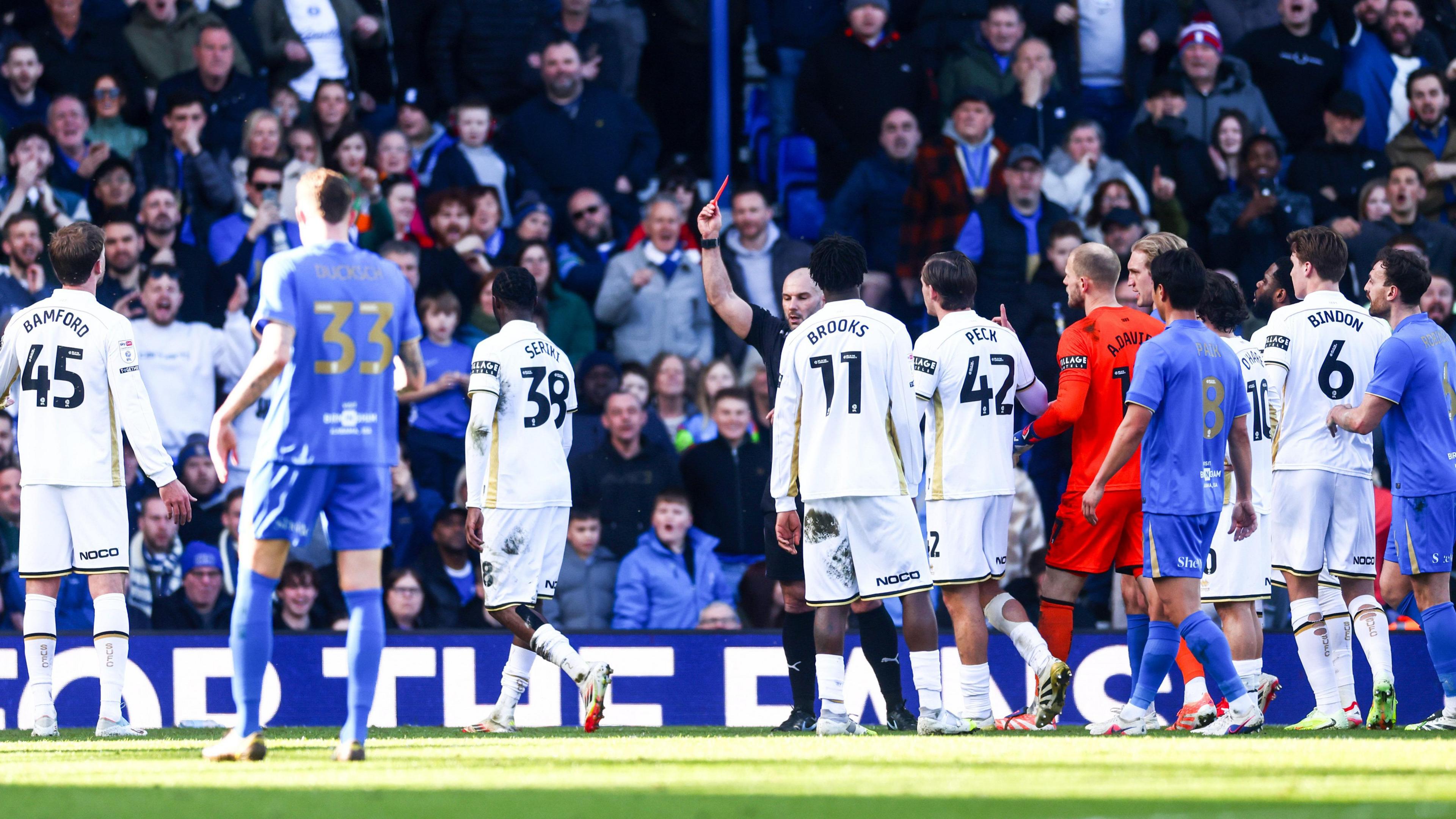 Referee Tim Robinson sends off Blades defender Femi Seriki