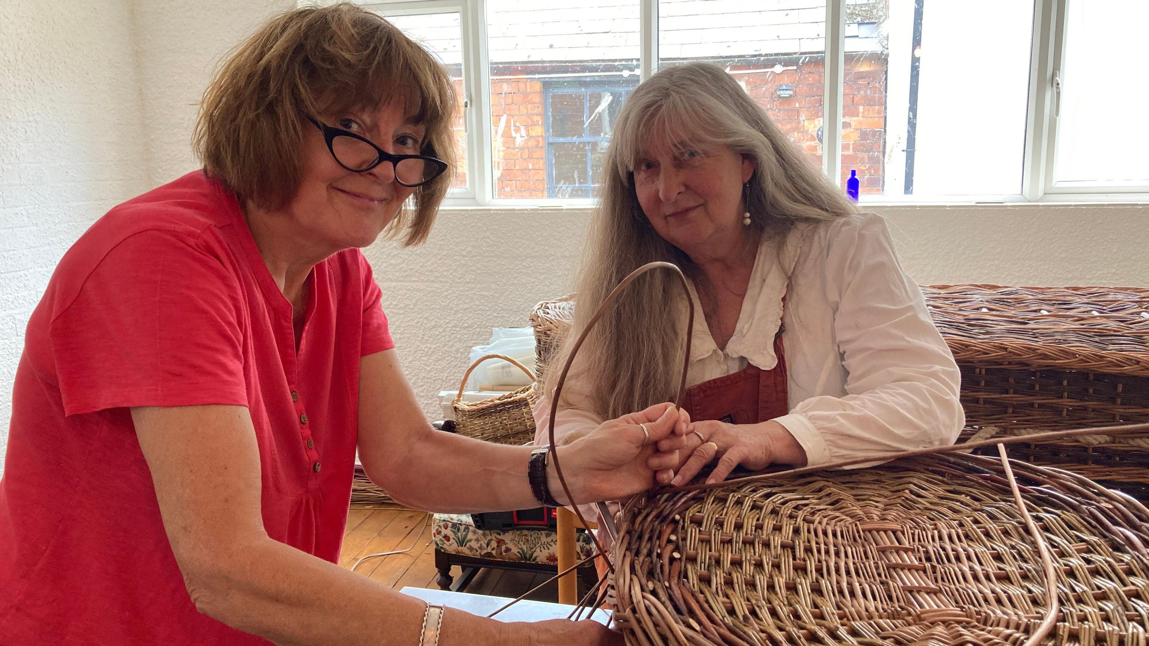 Helen and Amanda weaving a coffin made out of willow