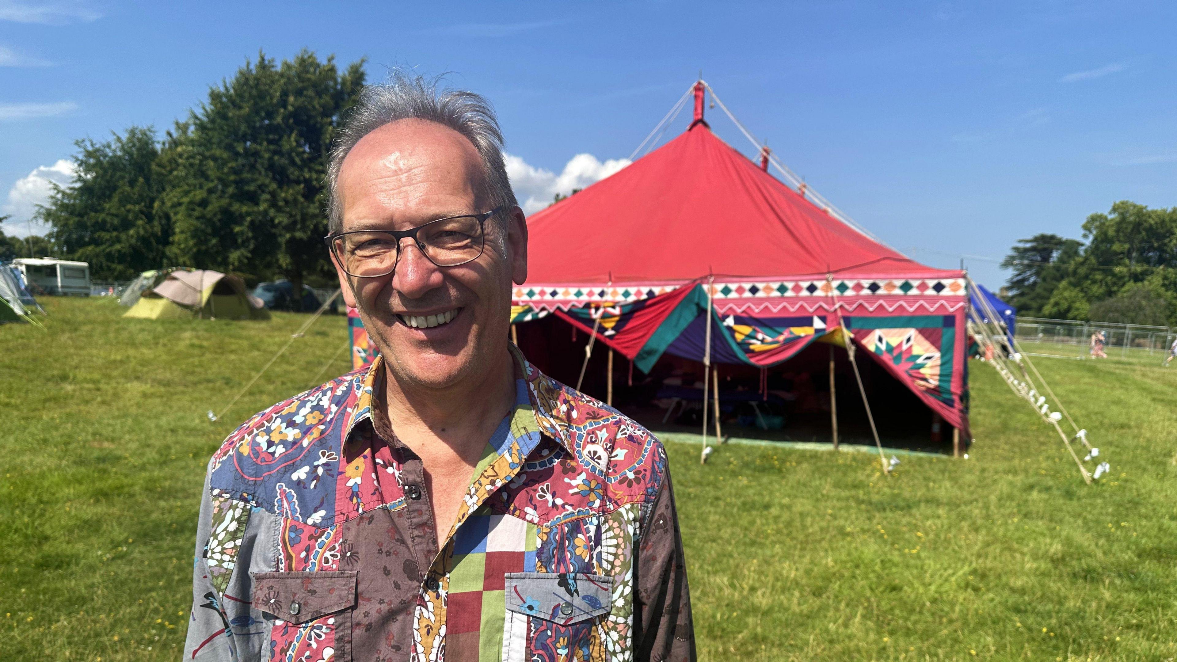 A picture of the co-founder of Festival Spirit, Steve Clarke. He's standing in front of their adapted tent