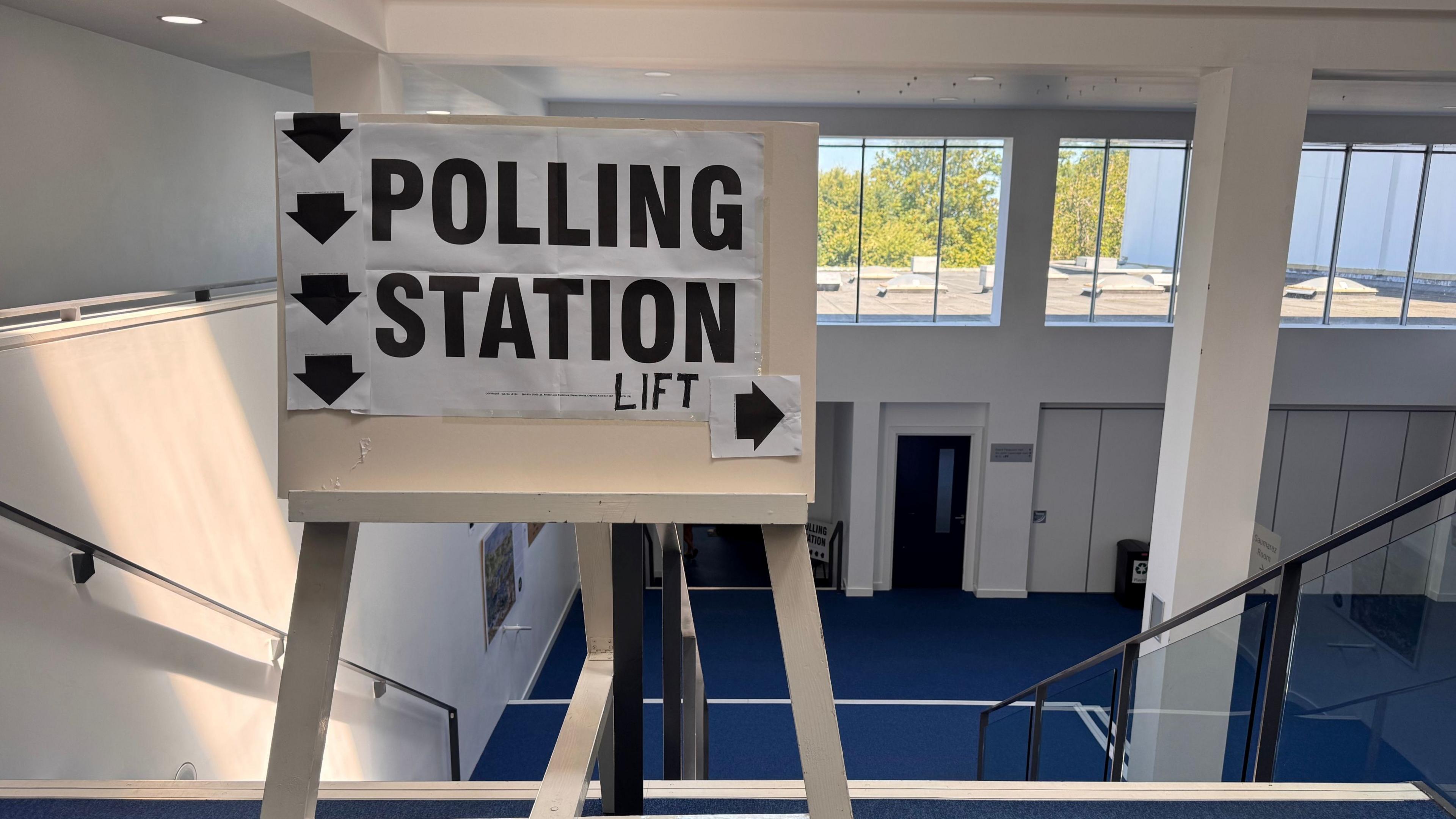 Polling station sign at the top of a staircase