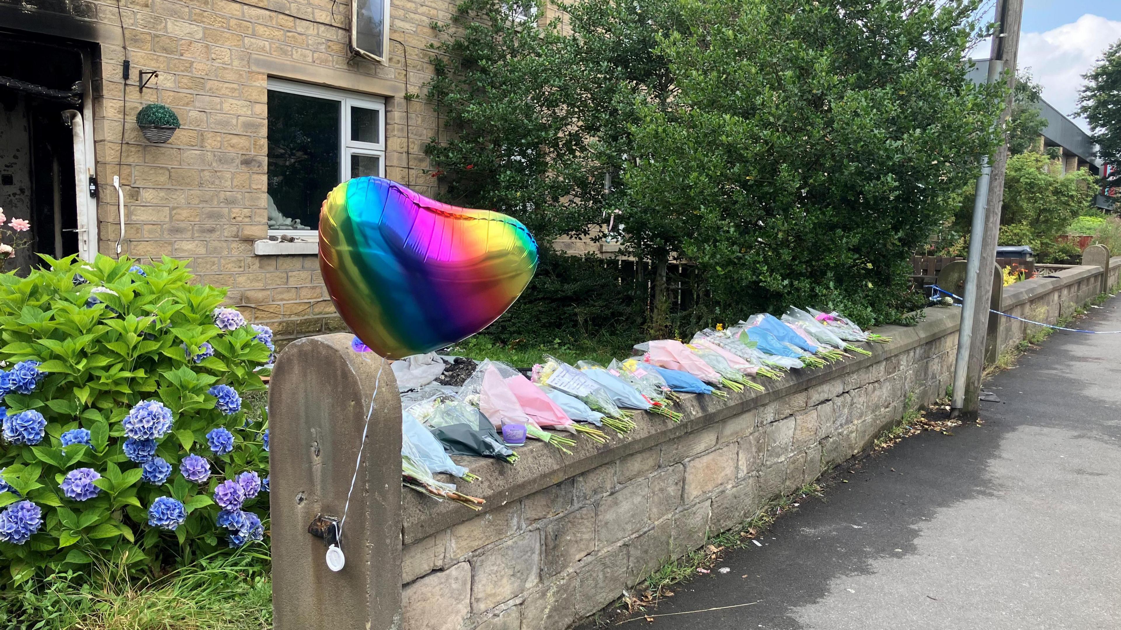 Flowers and balloon at the scene of the house fire