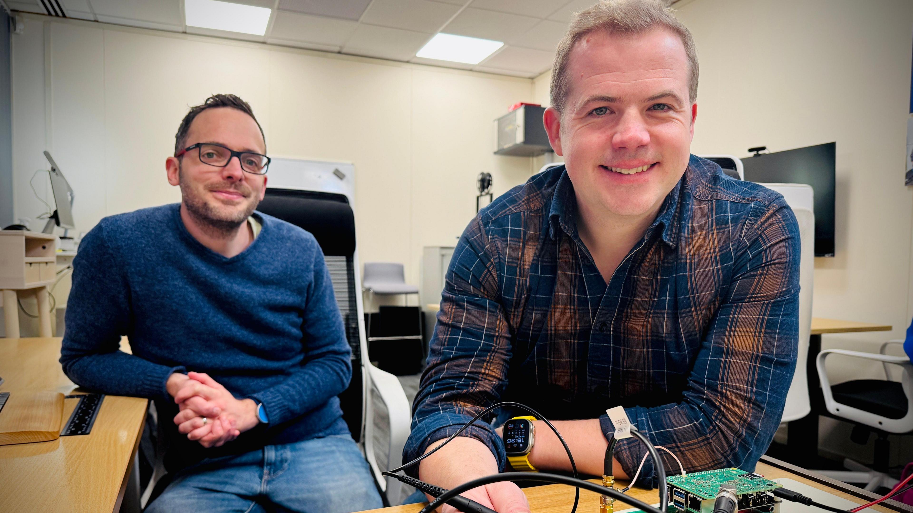 Dr Matt Ash and Dr James Brown working on electrical circuit boards at their office in Cambridge.