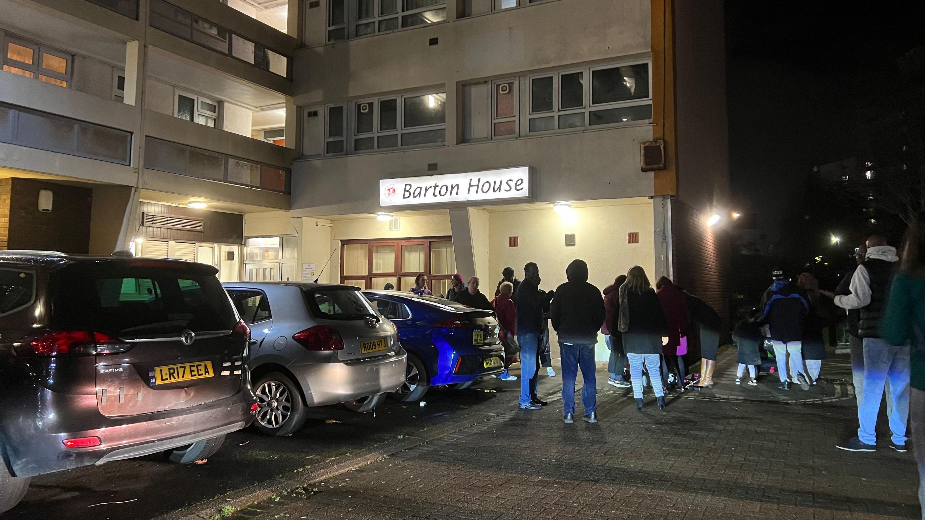 People standing outside Barton House in the car park on the night of the evacuation