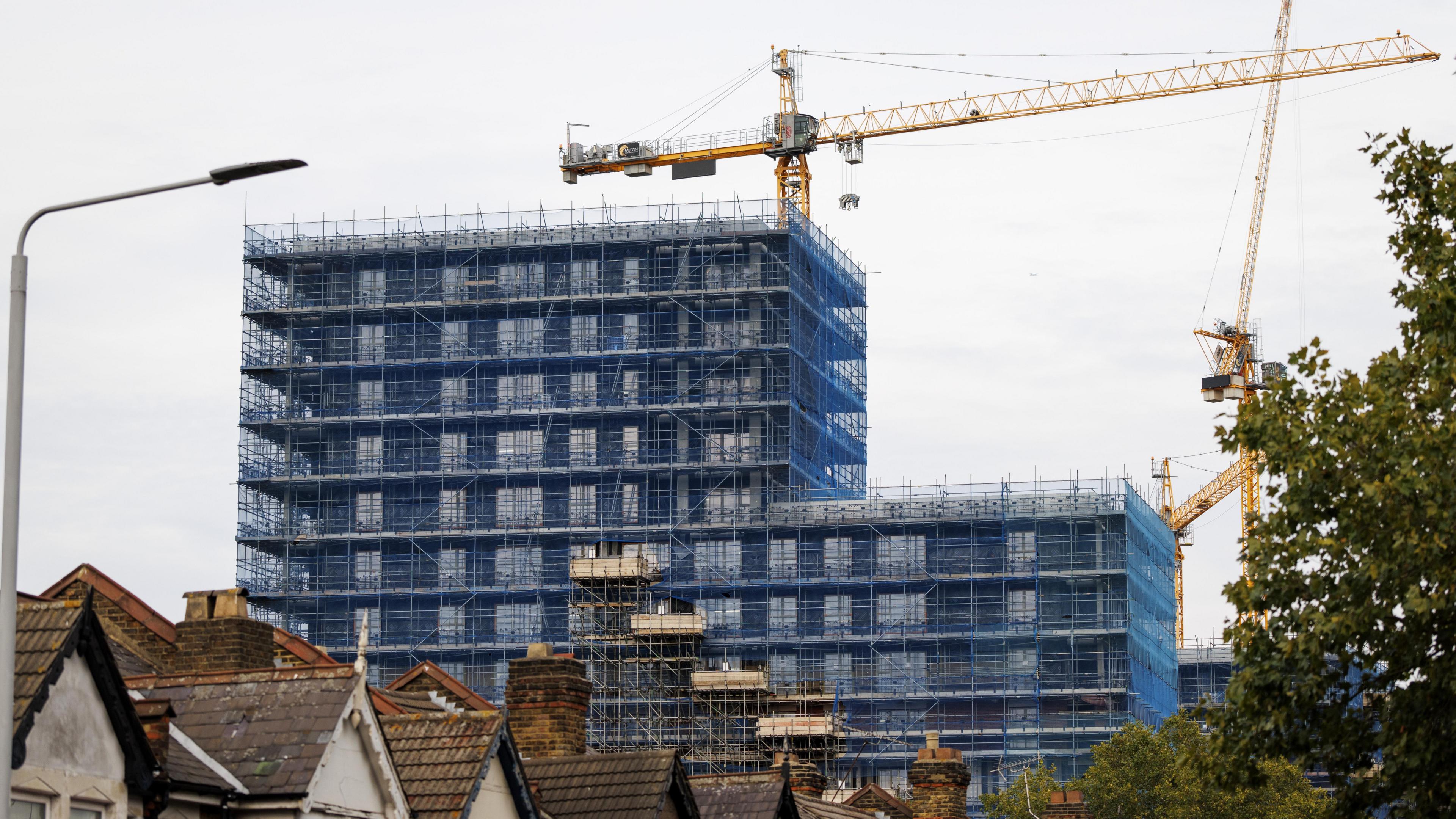 A block of flats is being built. There is a crane above it
