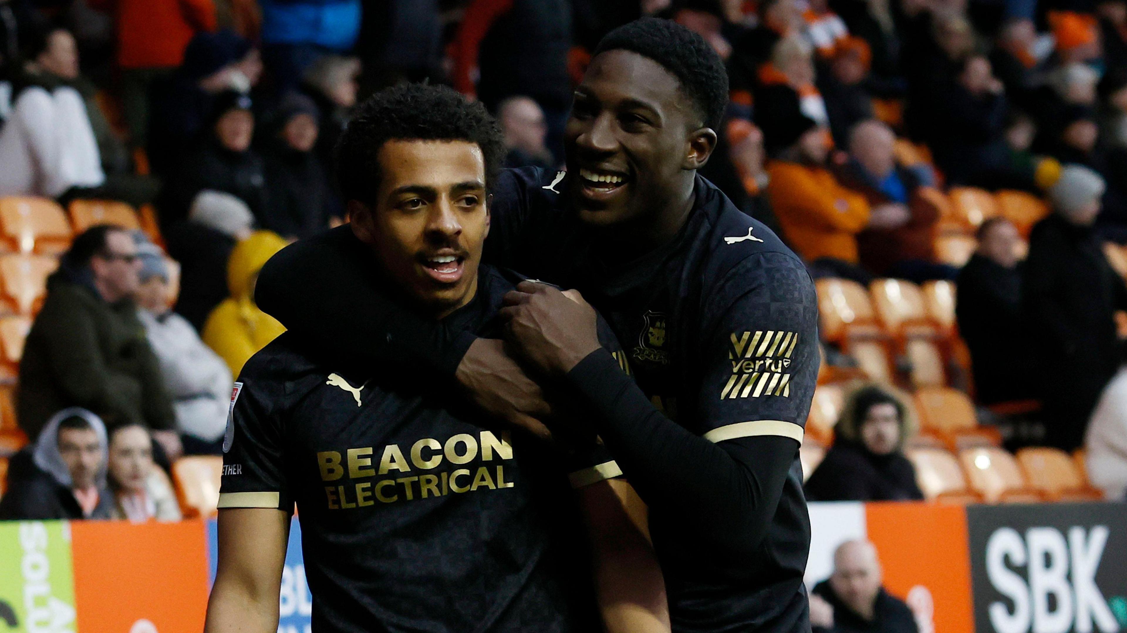 Caleb Watts and Aribim Pepple celebrating after Caleb Watts scores Plymouth Argyle's fourth goal against Blackpool.