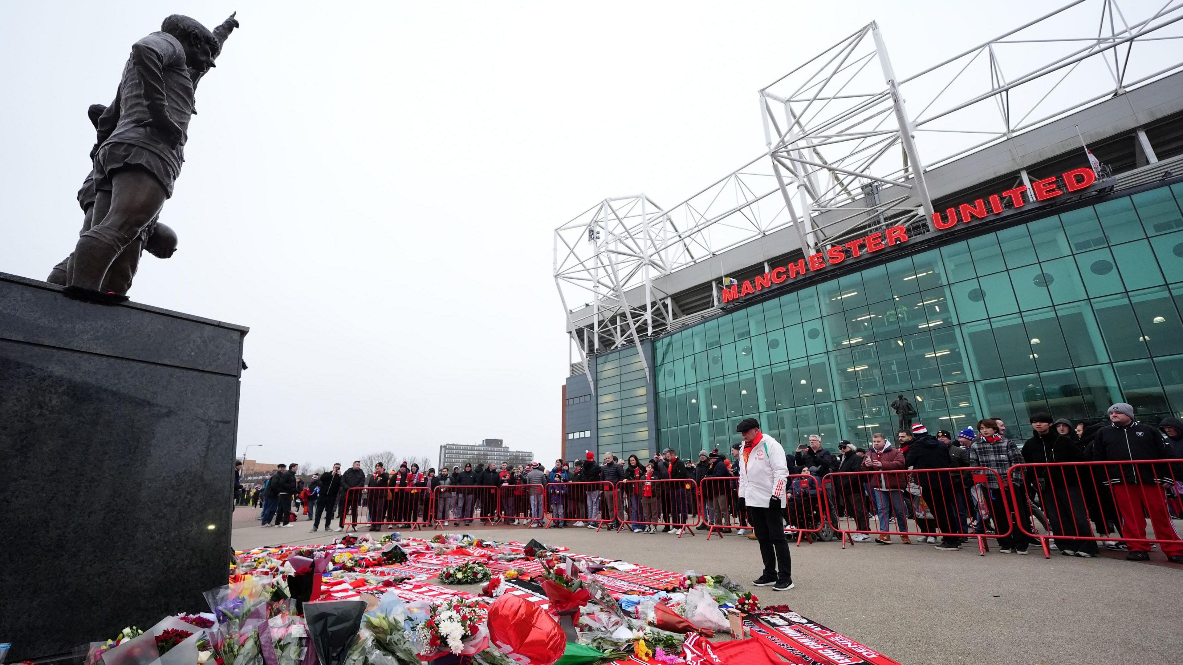 Tributes to the late Denis Law at the foot of the statue of the United Trinity 