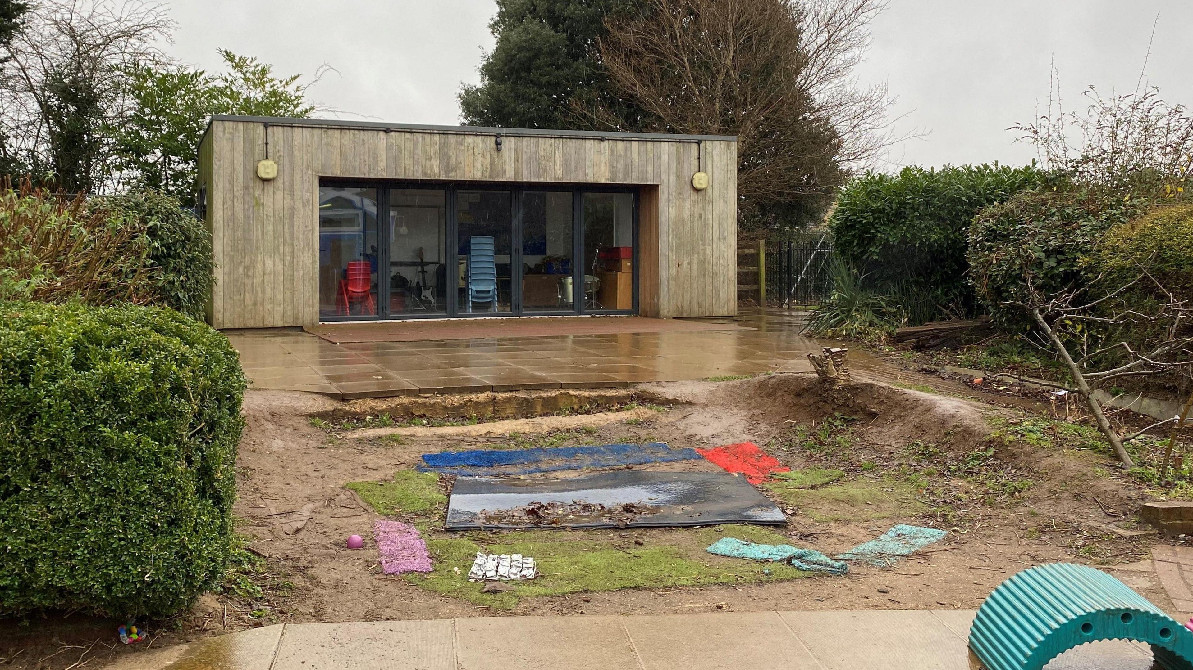 A large muddy hole with bits of tarpaulin in the centre