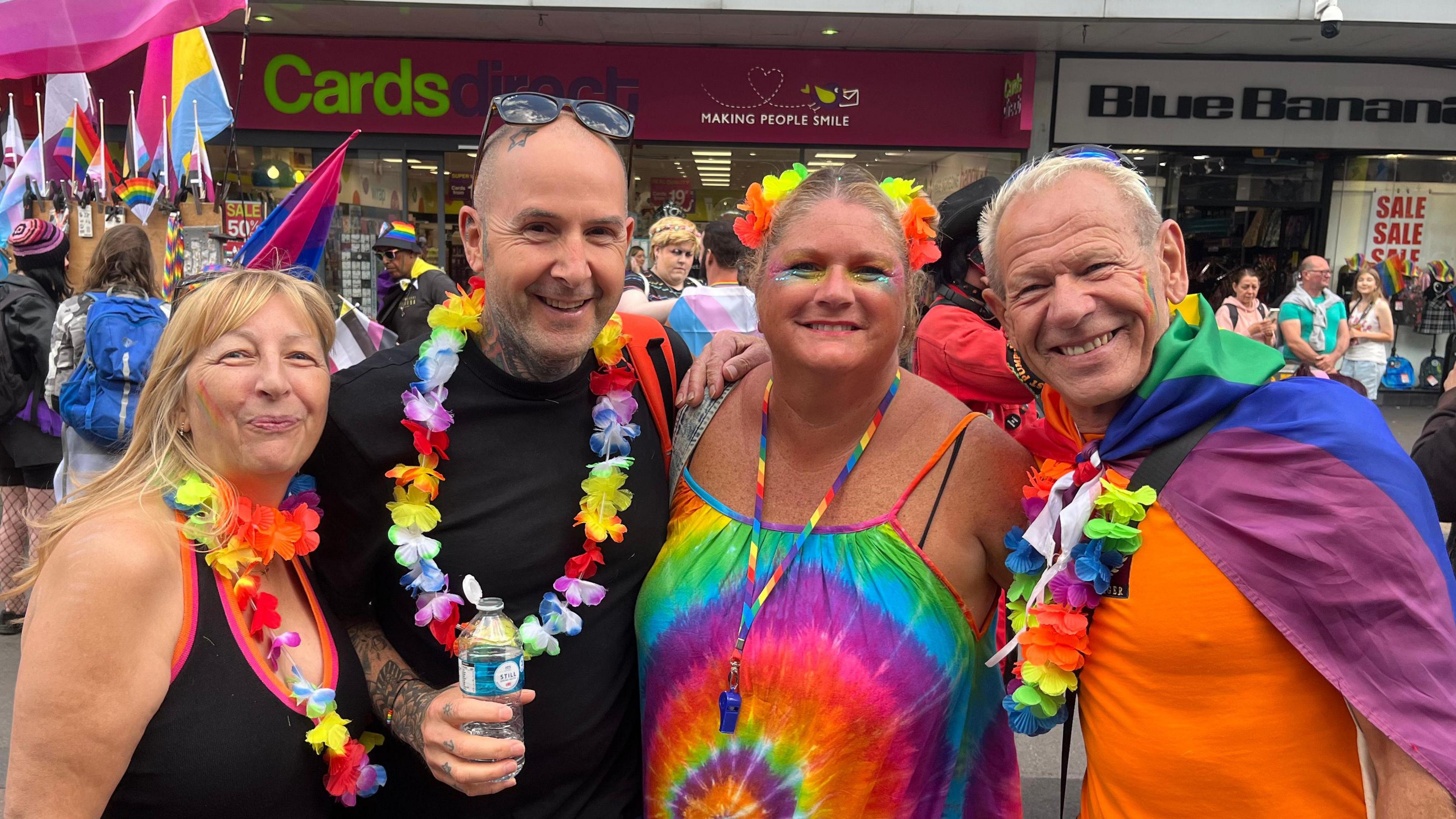 A group of friends wearing multi-coloured outfits at Leicester Pride 2024 