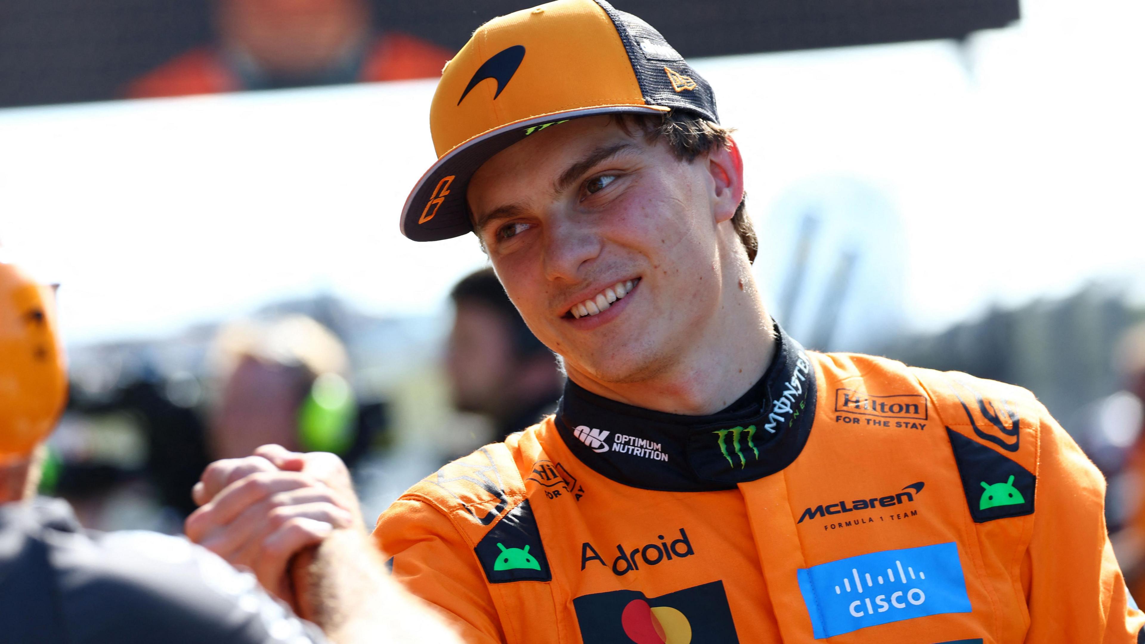 McLaren's clasps hands with a McLaren engineer after taking pole position for the Dutch Grand Prix