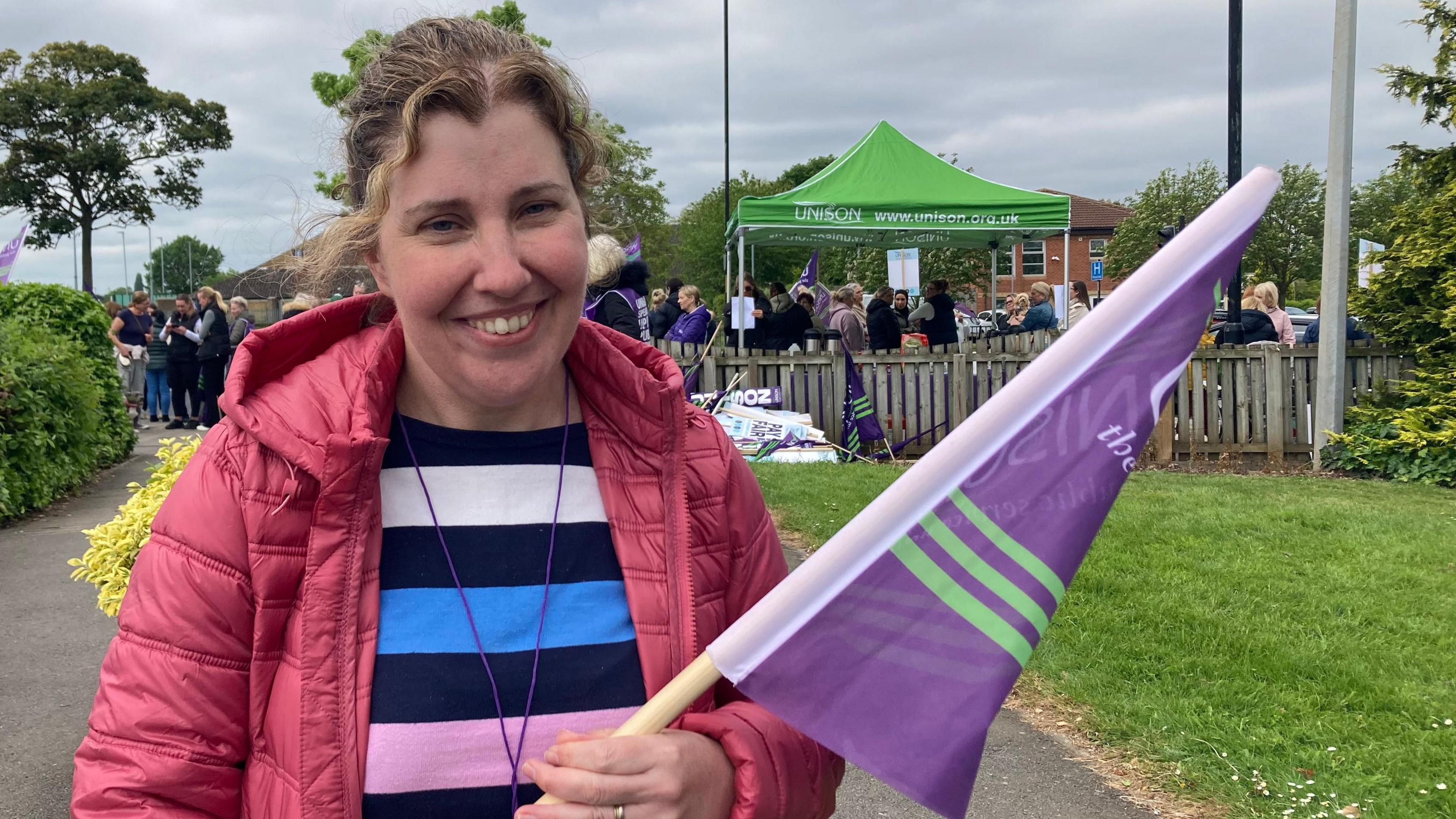 A Unison union member holding a flag on the picket line