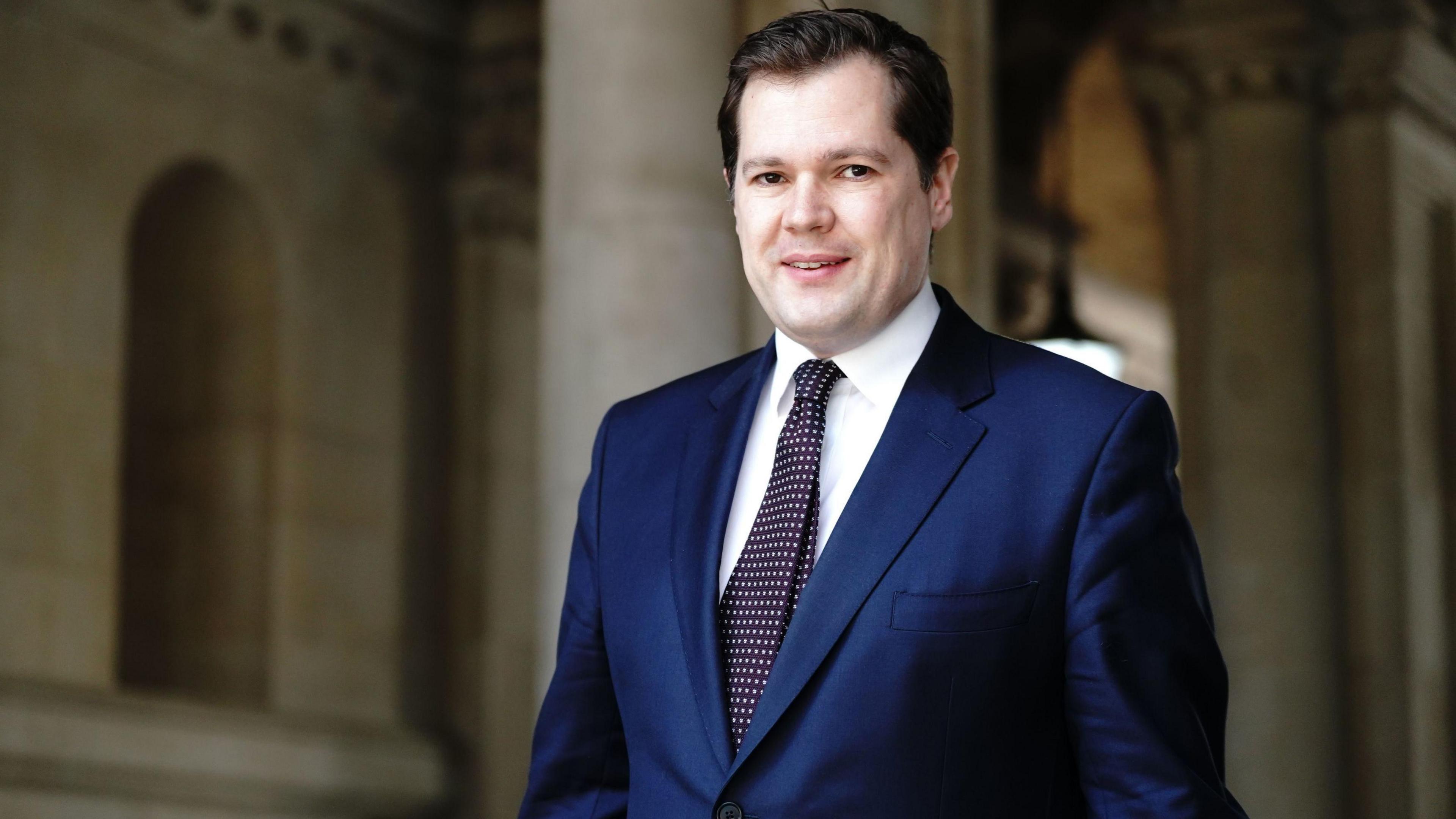 Robert Jenrick wearing a suit and tie