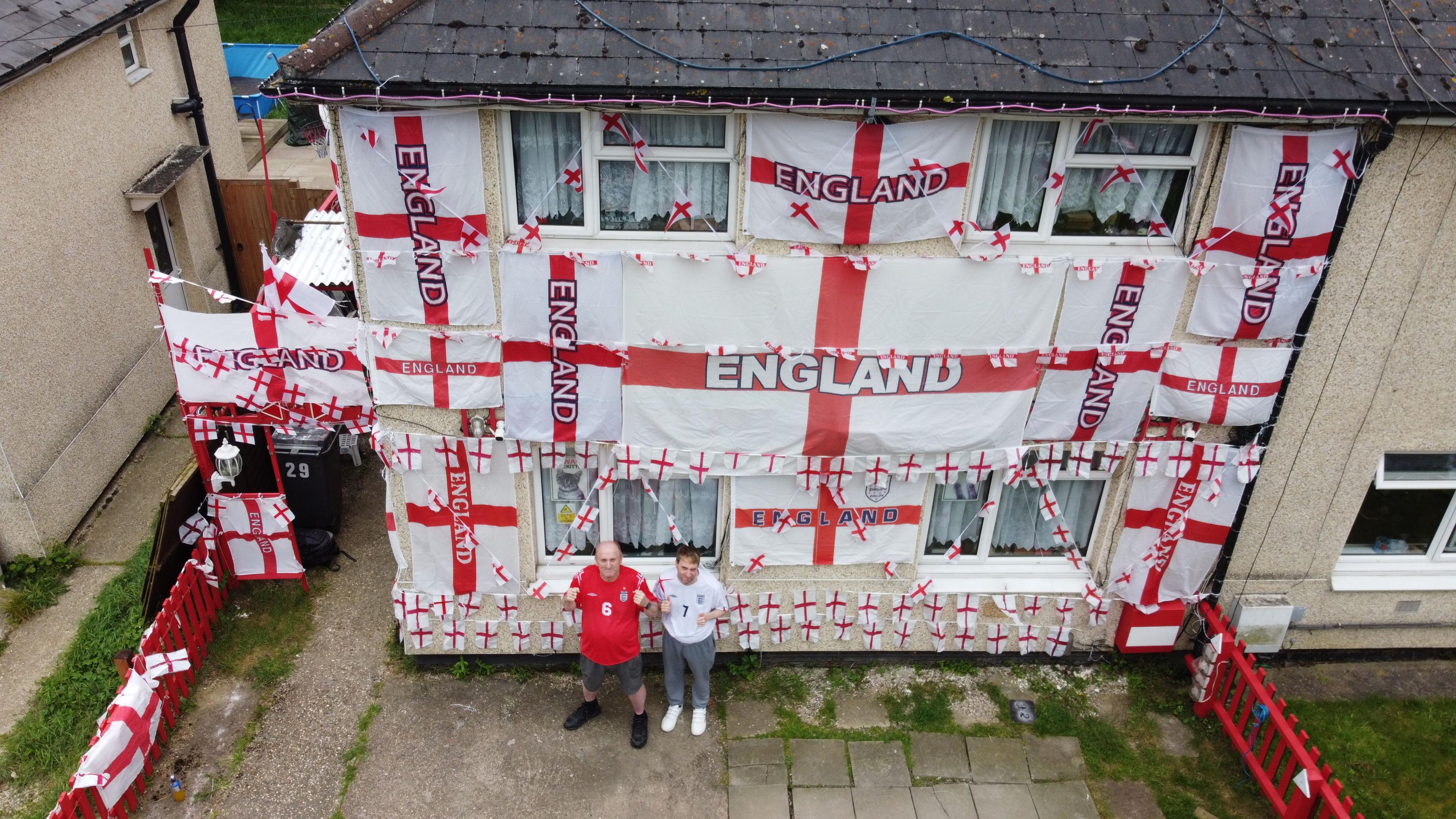 Paul and Aarson Bibby standing in front of their home