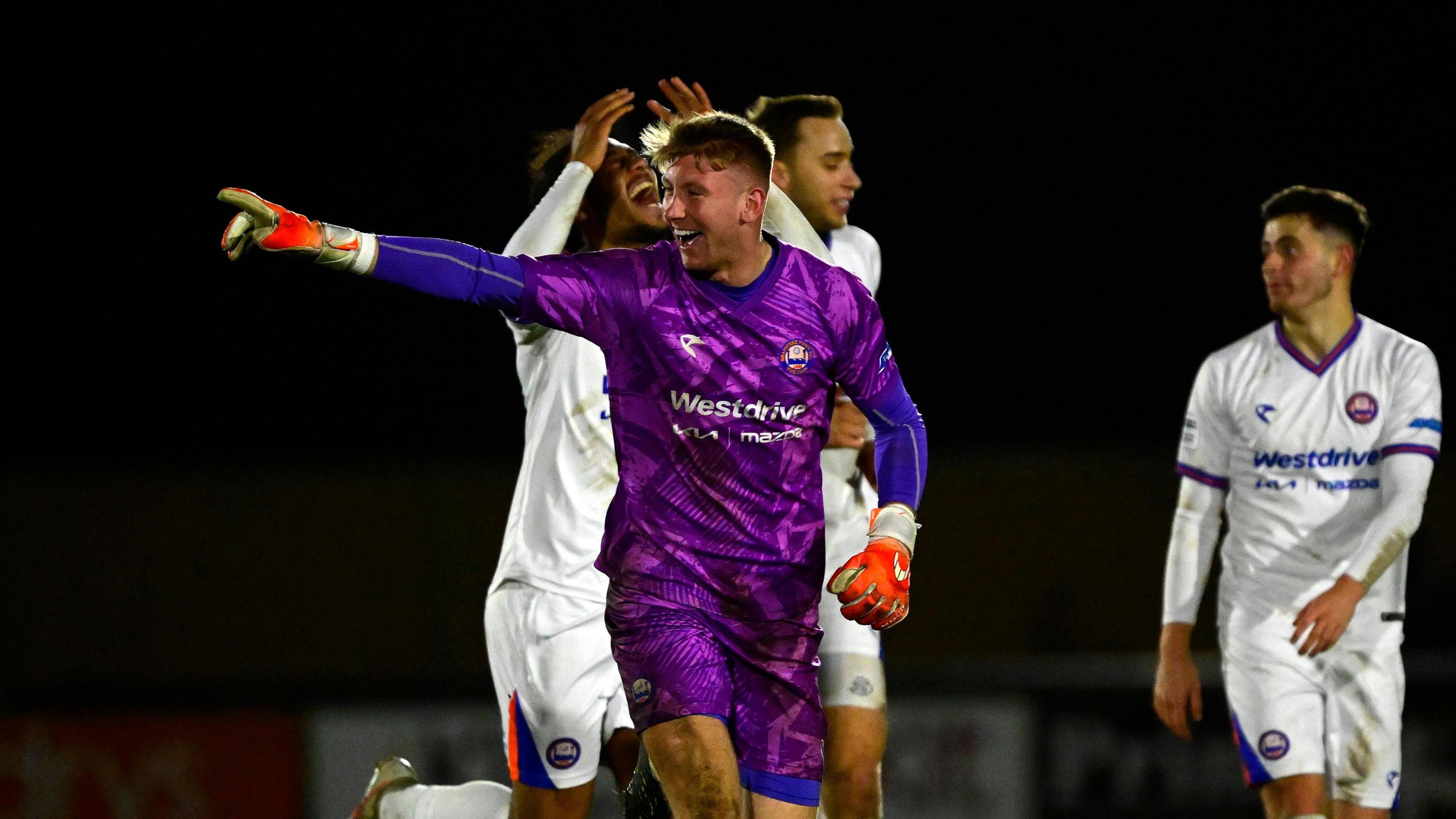 A photo of Mason Terry, in his purple goalkeeping kit for Braintree Town, celebrating a goal against Truro City in the National League Cup in February
