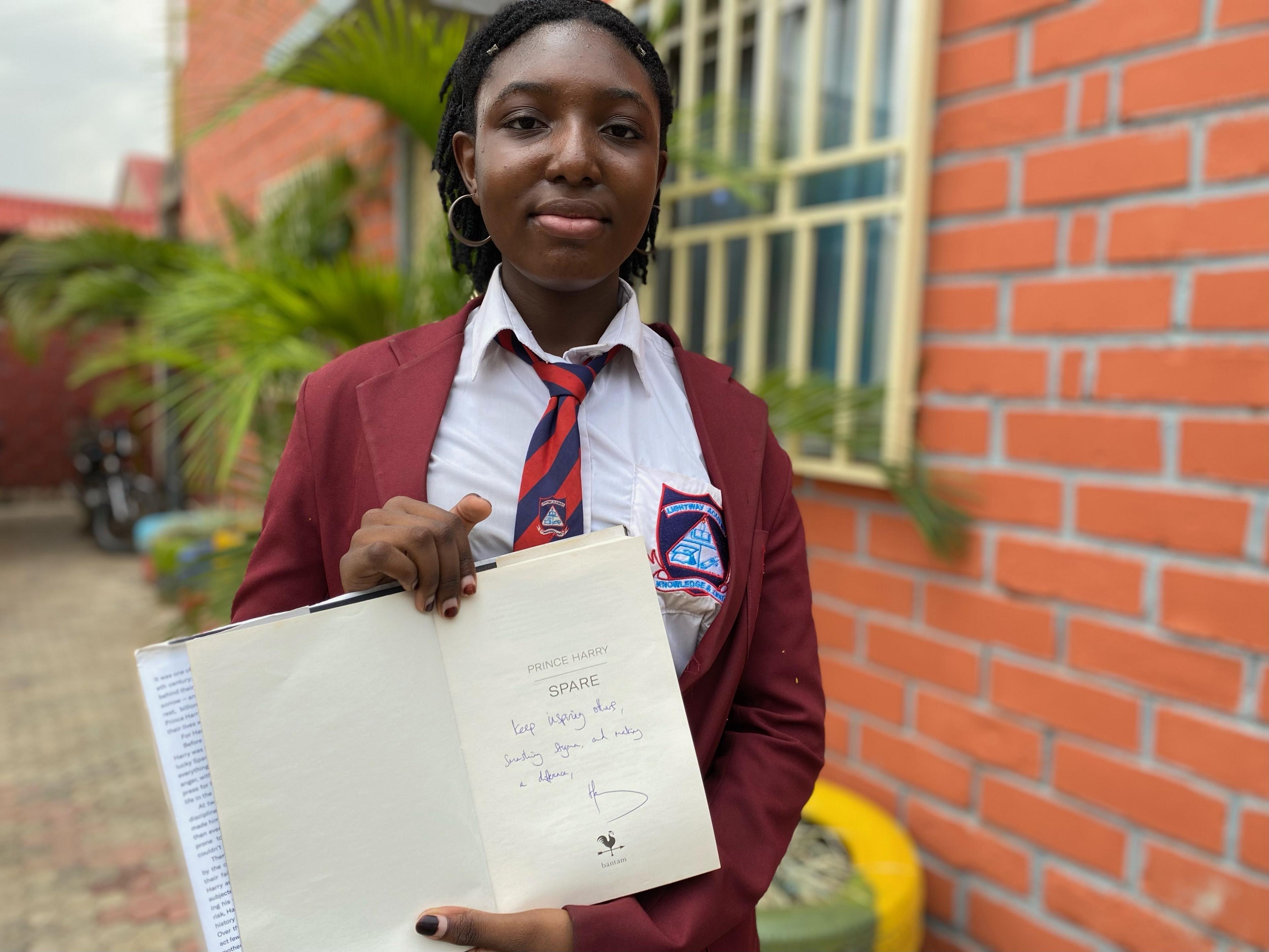  Valeria Offia holds up signed copy of Prince Harry's book Spare